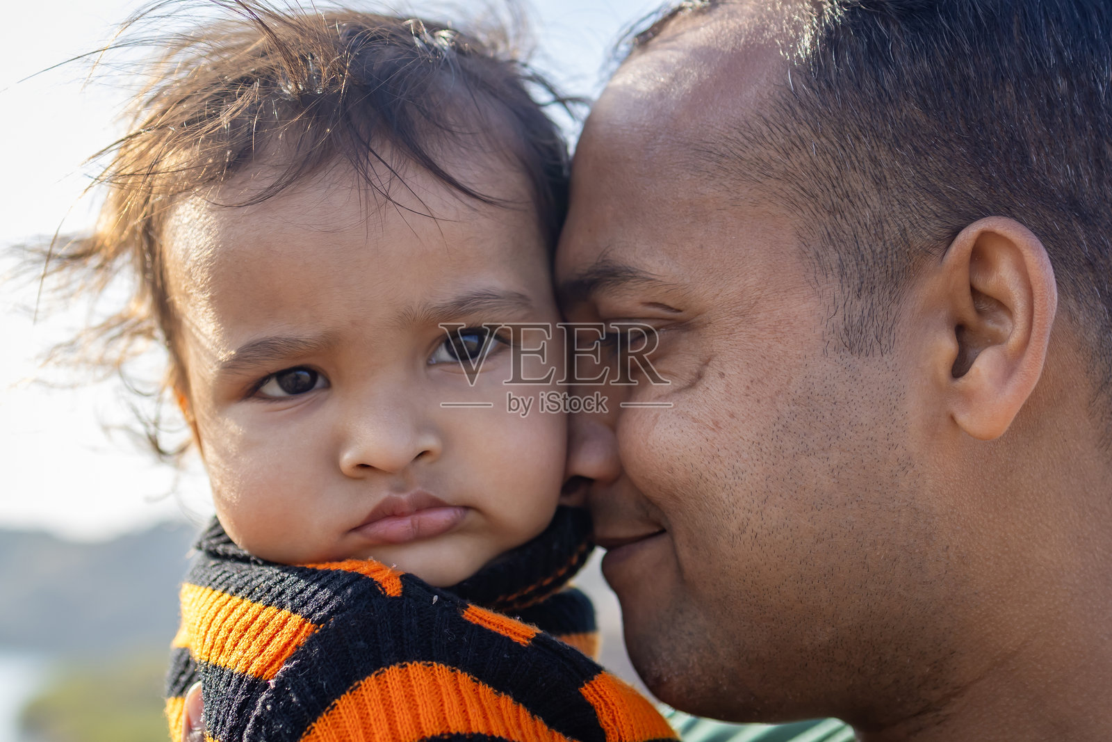 父子亲密互动的特写镜头，拍摄于早晨的户外照片摄影图片