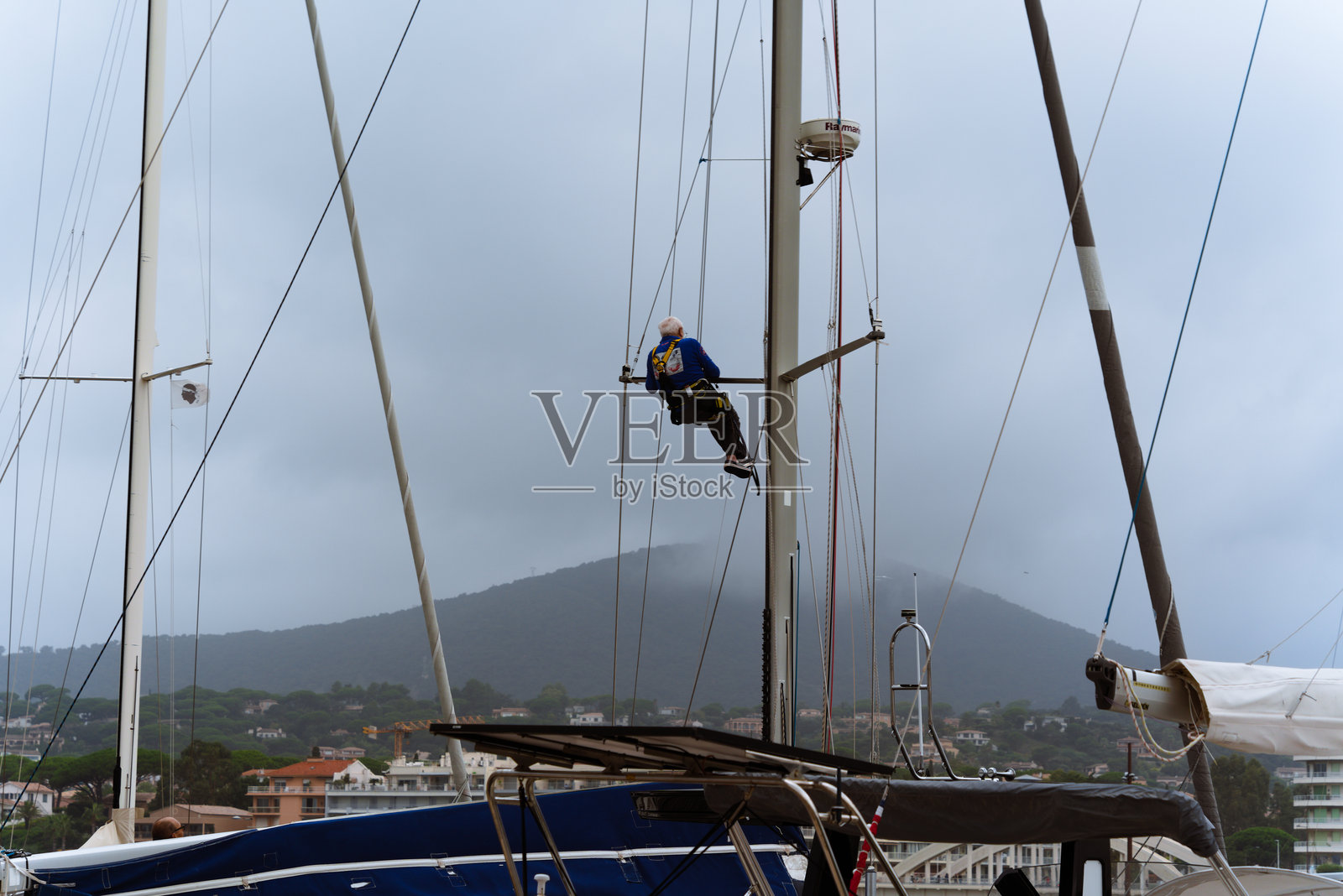 在阴天的帆船桅杆上栖息照片摄影图片