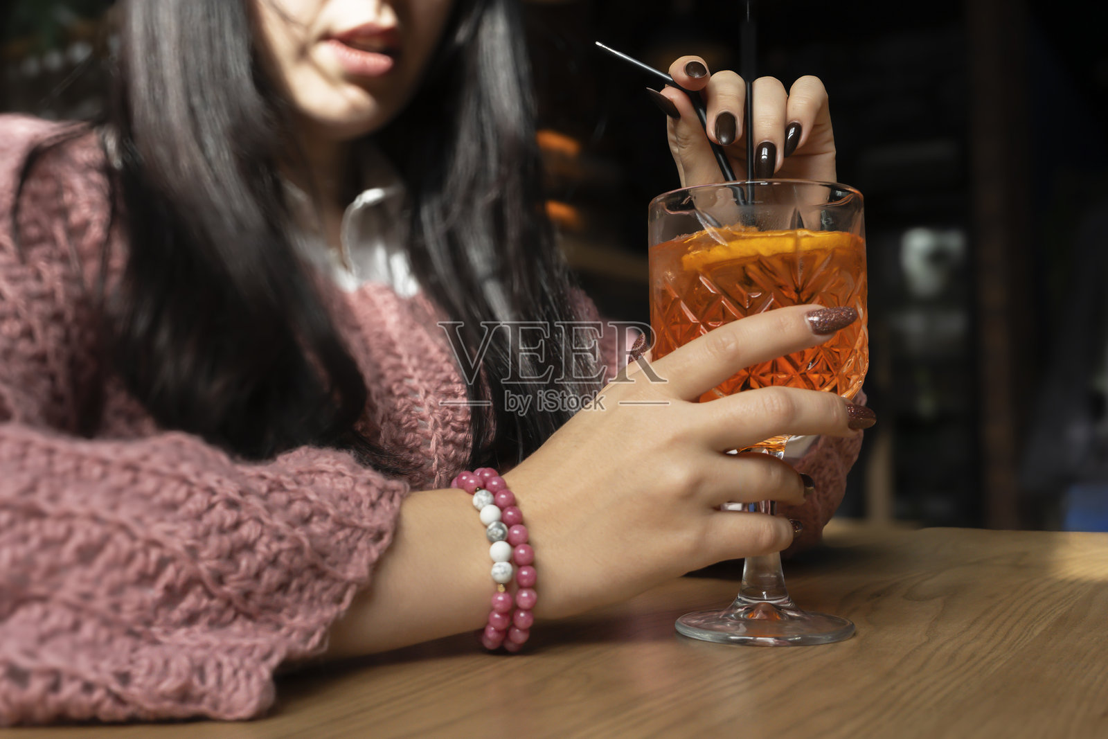 女性手中拿着的阿佩罗鸡尾酒特写。照片摄影图片