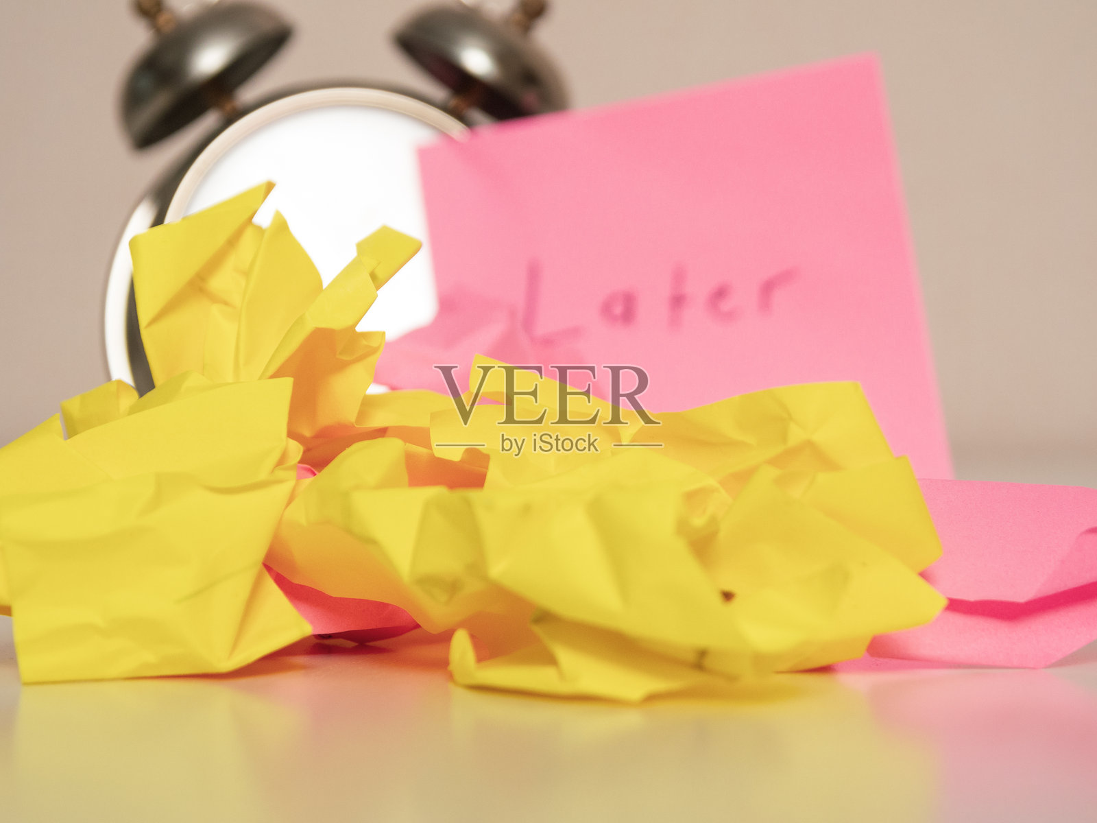 皱巴巴的纸片与“稍后”字样的背景代表了被推迟的任务和创造性的时间管理方法。照片摄影图片