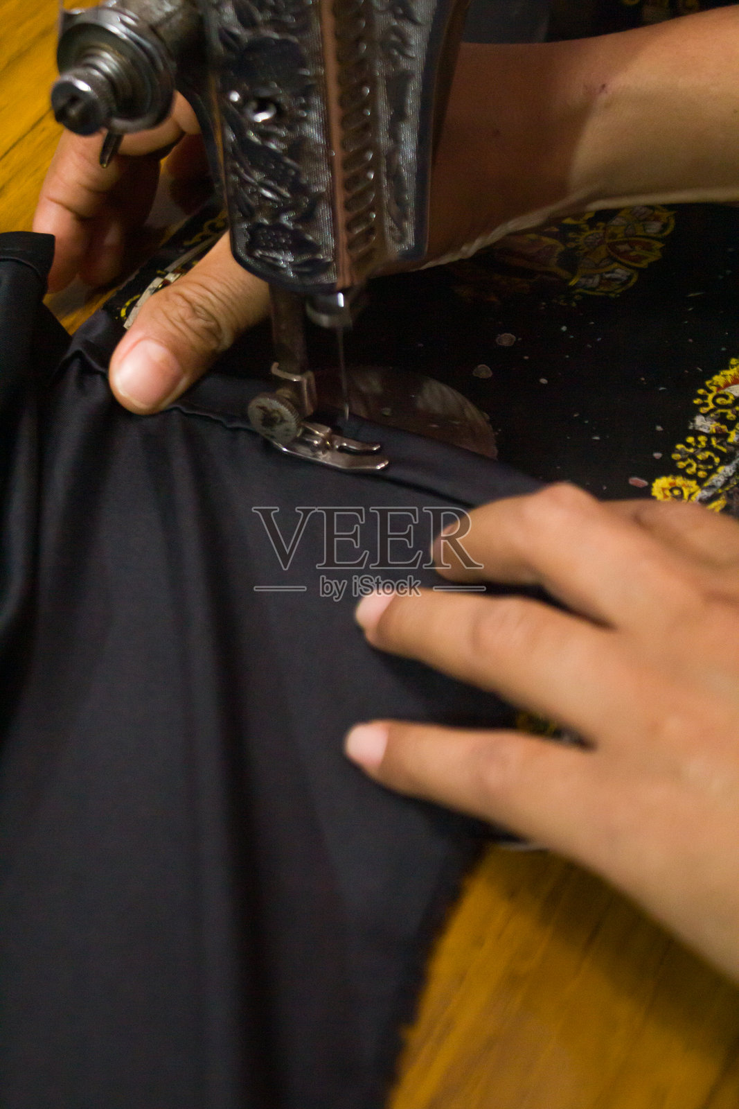 使用传统缝纫机从一块布料制作衣物的裁缝照片摄影图片