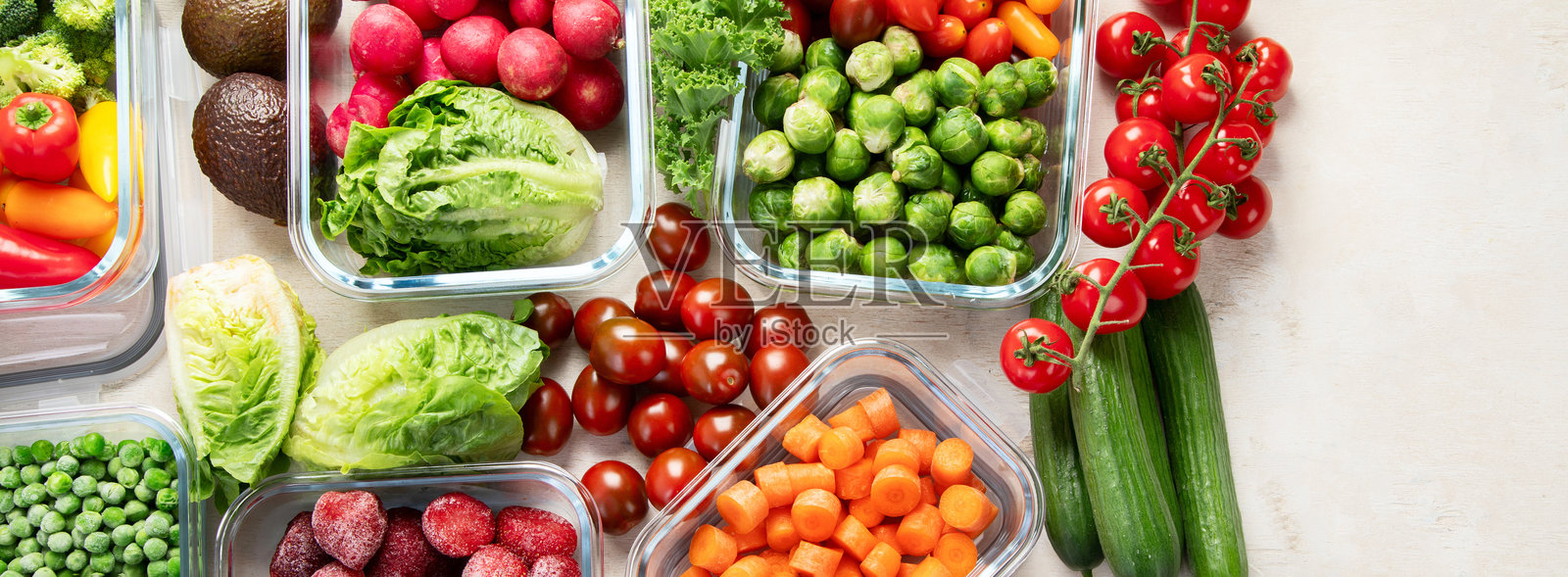 桌子上放着装有新鲜生蔬菜的盒子。照片摄影图片