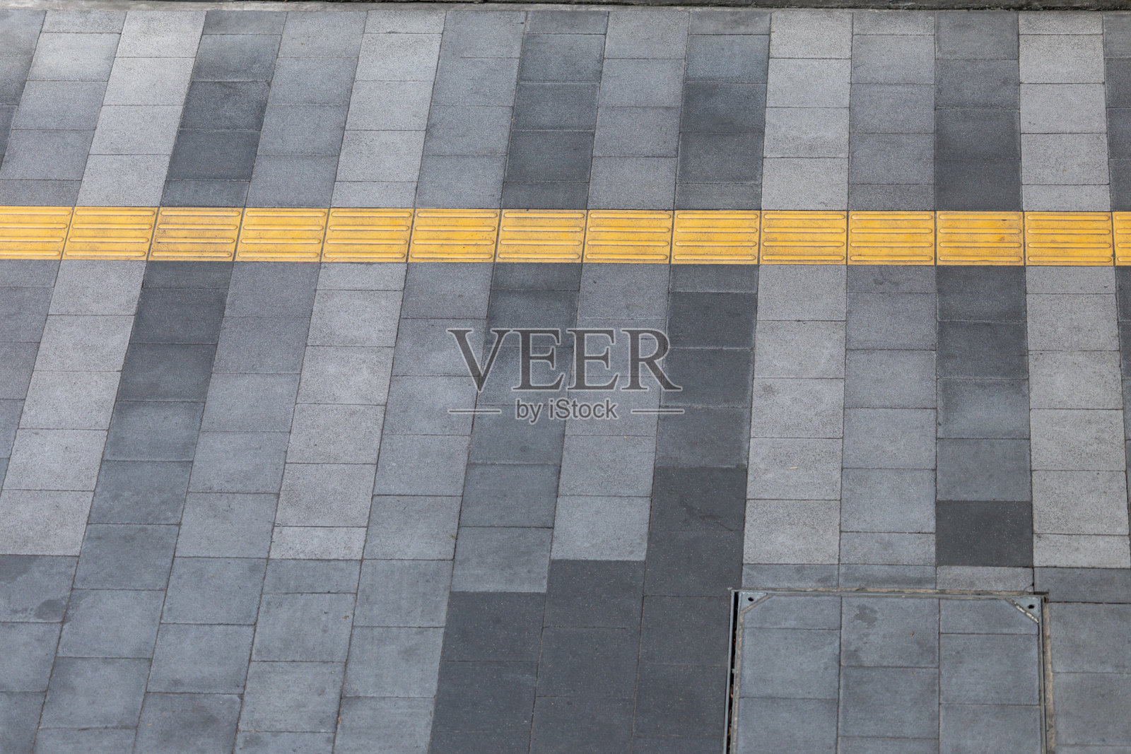 一条灰黑色的人行道，中间有一条黄色的线。照片摄影图片