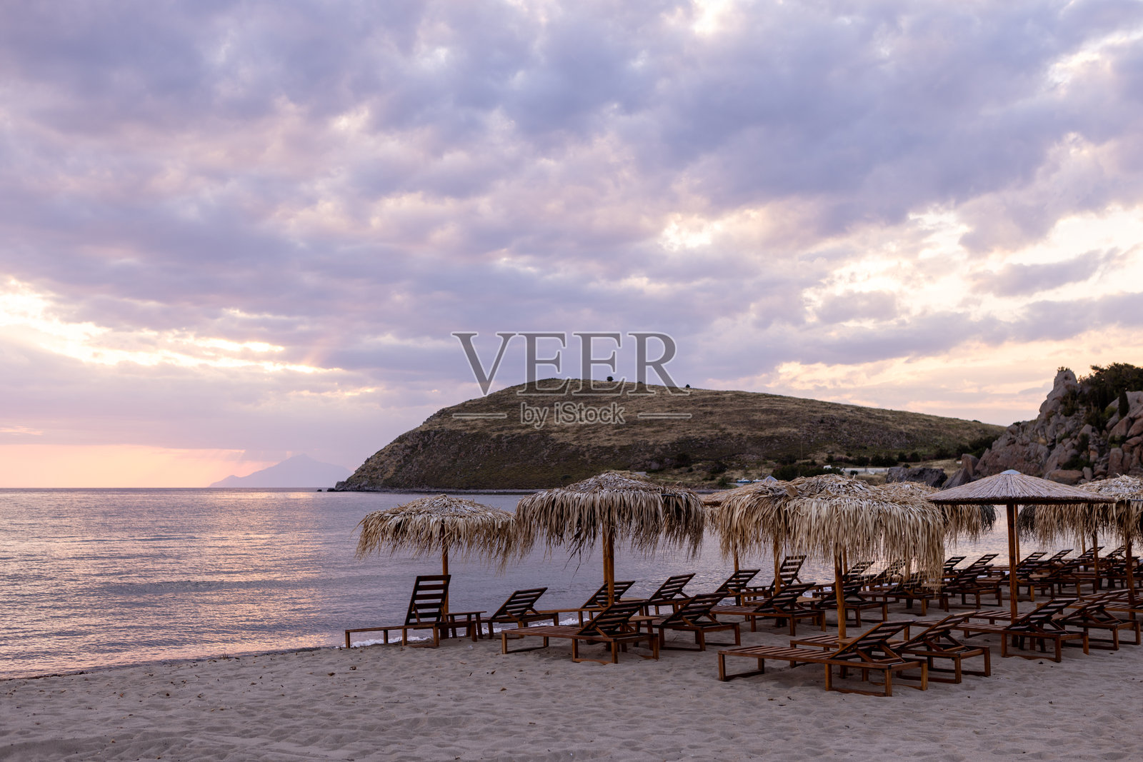 日落时海滩上的太阳伞照片摄影图片