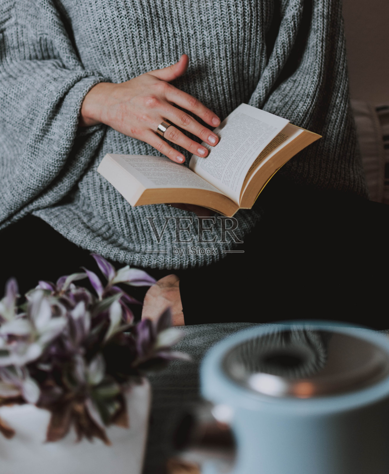 女性手持书籍的中部特写照片摄影图片