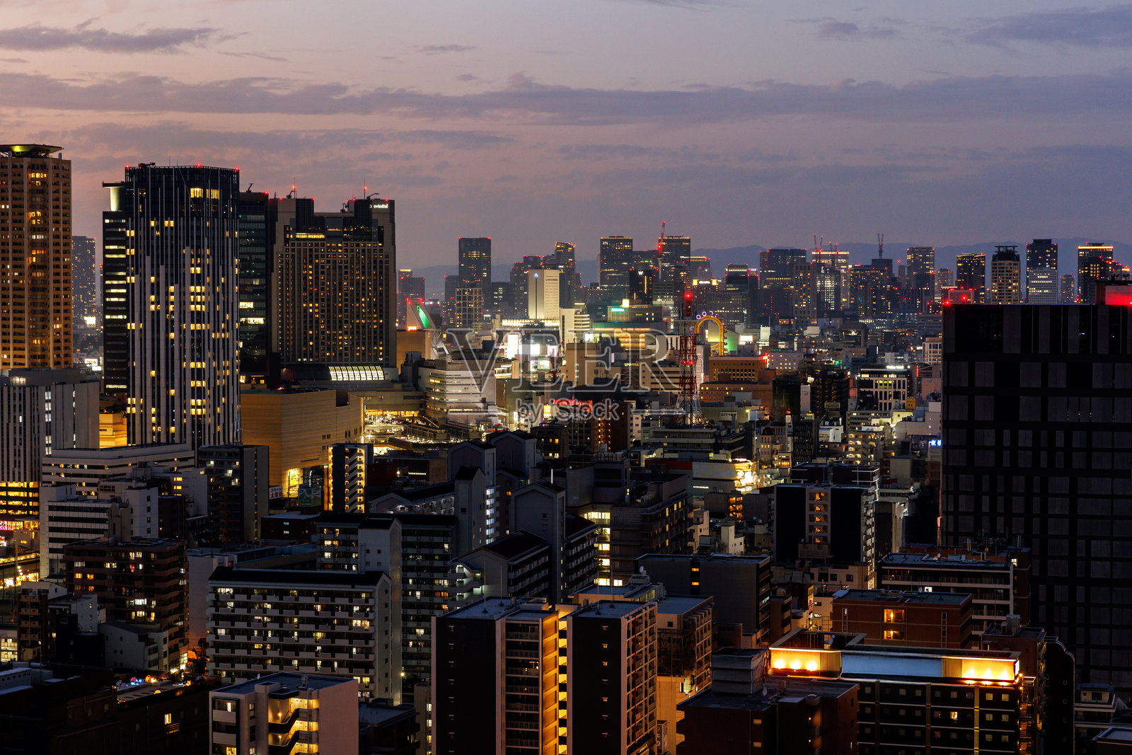 黄昏时分，令人惊叹的充满活力的大阪城市景观，摩天大楼与灯光璀璨的街道。照片摄影图片