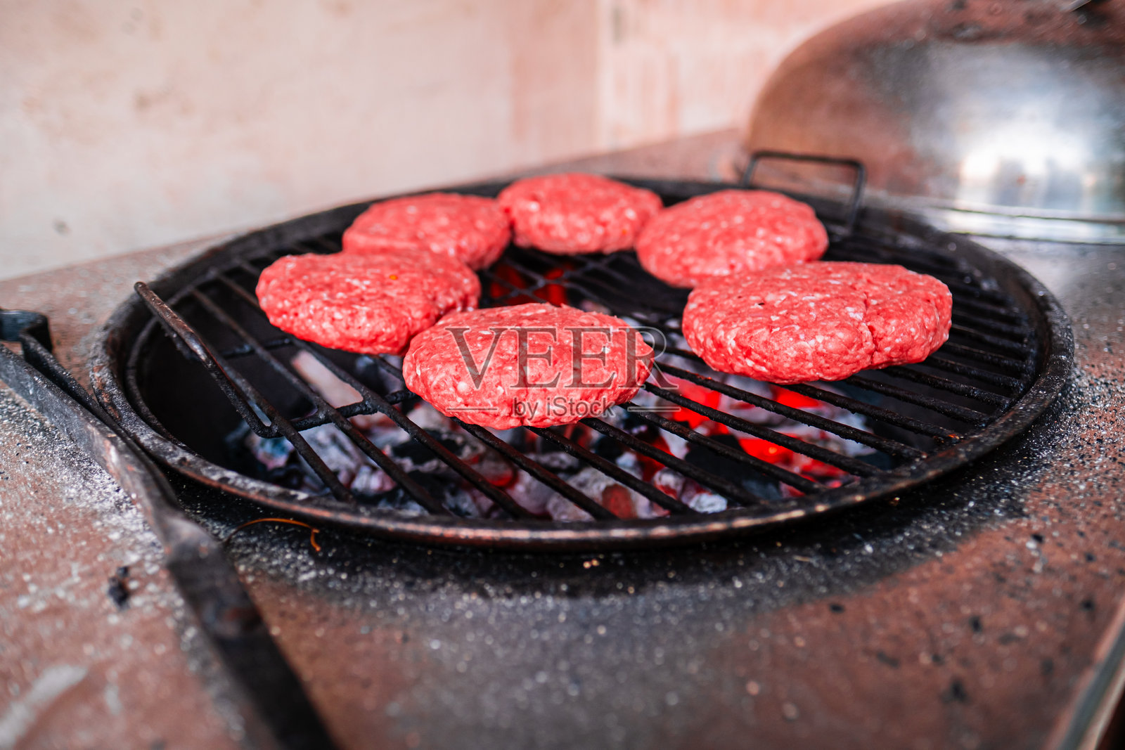 新鲜制作的牛肉饼在炭火烧烤架上烹饪，适合烧烤活动的特写镜头照片摄影图片