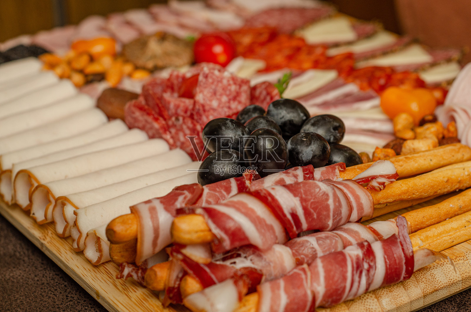 准备好的装饰肉类和奶酪开胃菜。培根串的特写照片。照片摄影图片