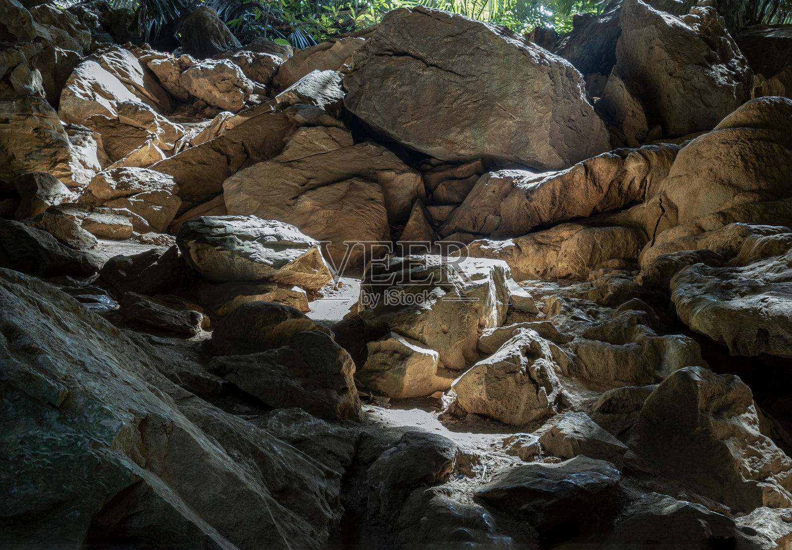 复杂的阳光透过洞穴照射到Hup Pa Tat洞穴内的钟乳石上。照片摄影图片