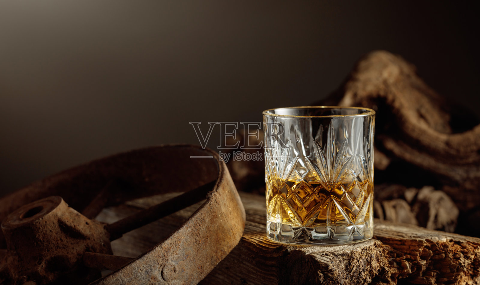 水晶杯中的威士忌放在古老的木板上。照片摄影图片
