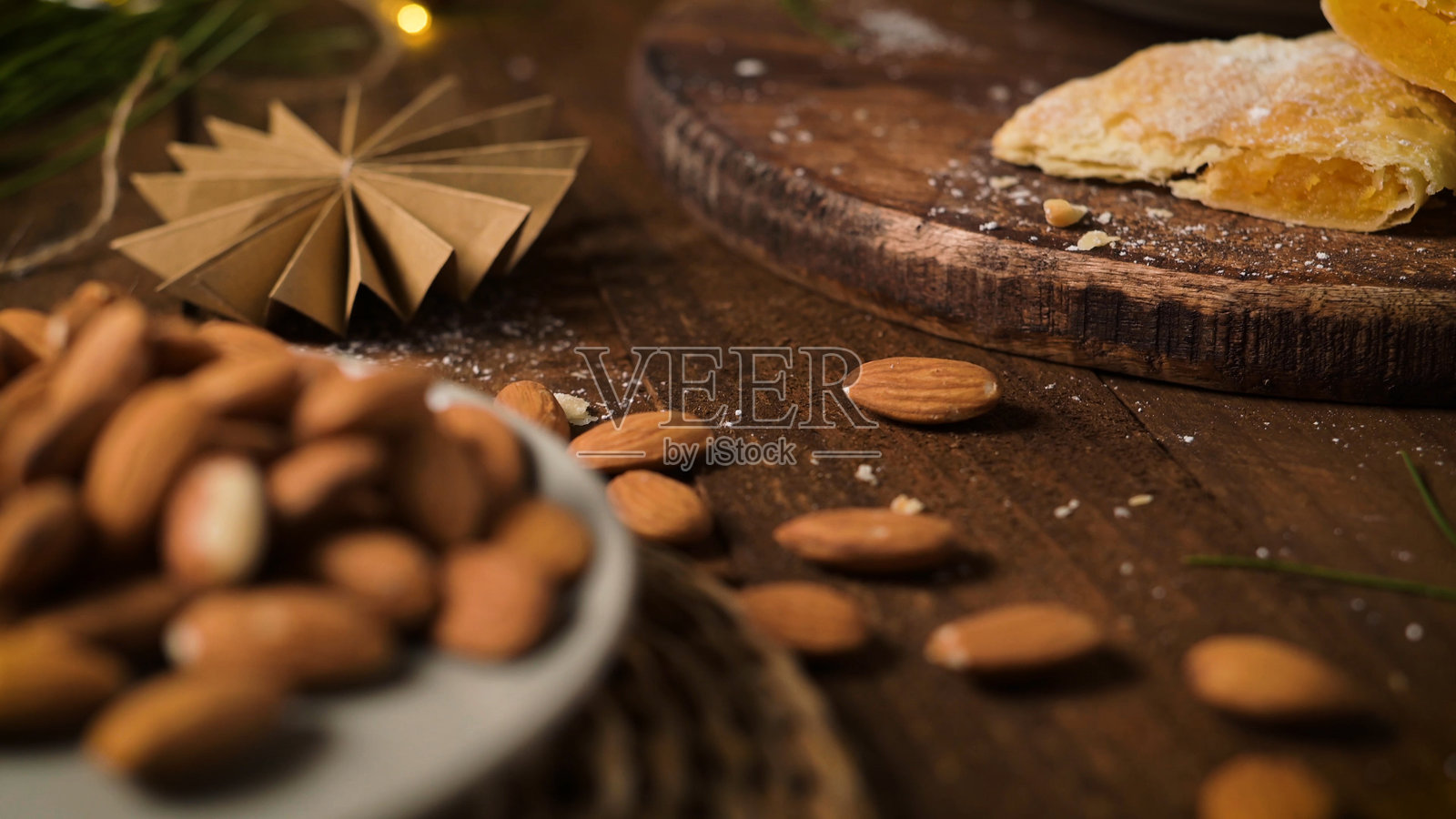 散落在木质表面上的杏仁，背景是节日的圣诞氛围照片摄影图片