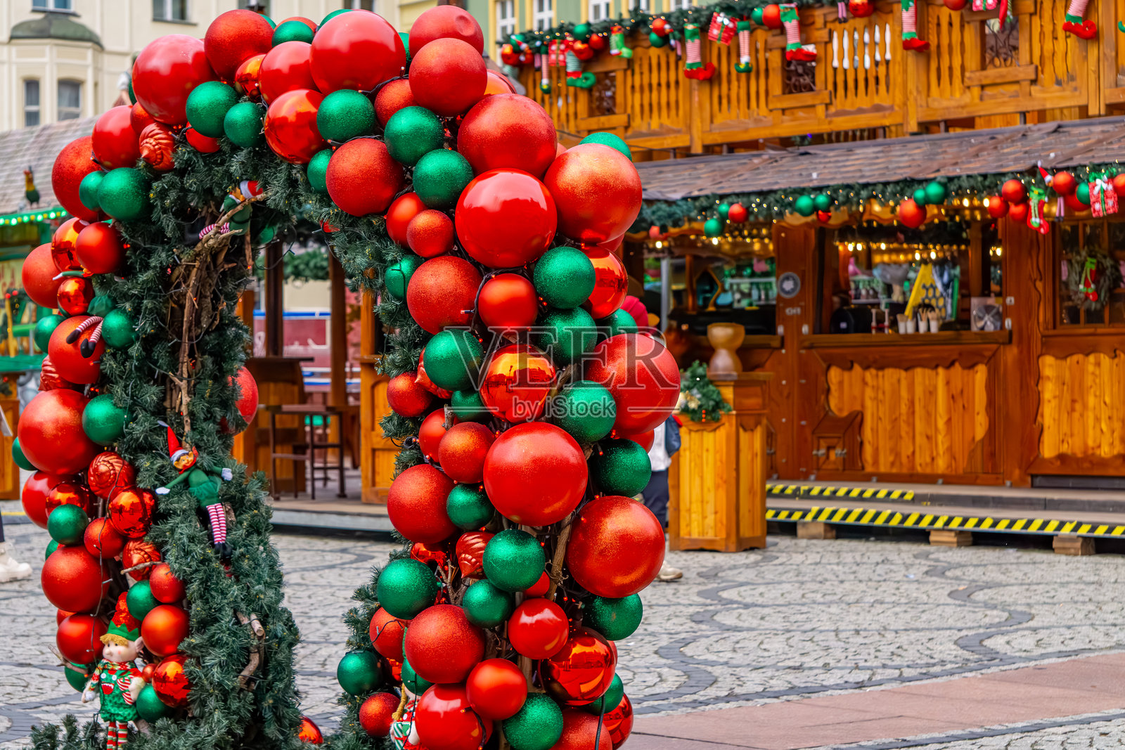 节日装饰的城市。闪烁的灯光，灯笼映衬着城市建筑的背景。圣诞节。悬挂的发光装饰品。大型的软木球。圣诞市场。照片摄影图片