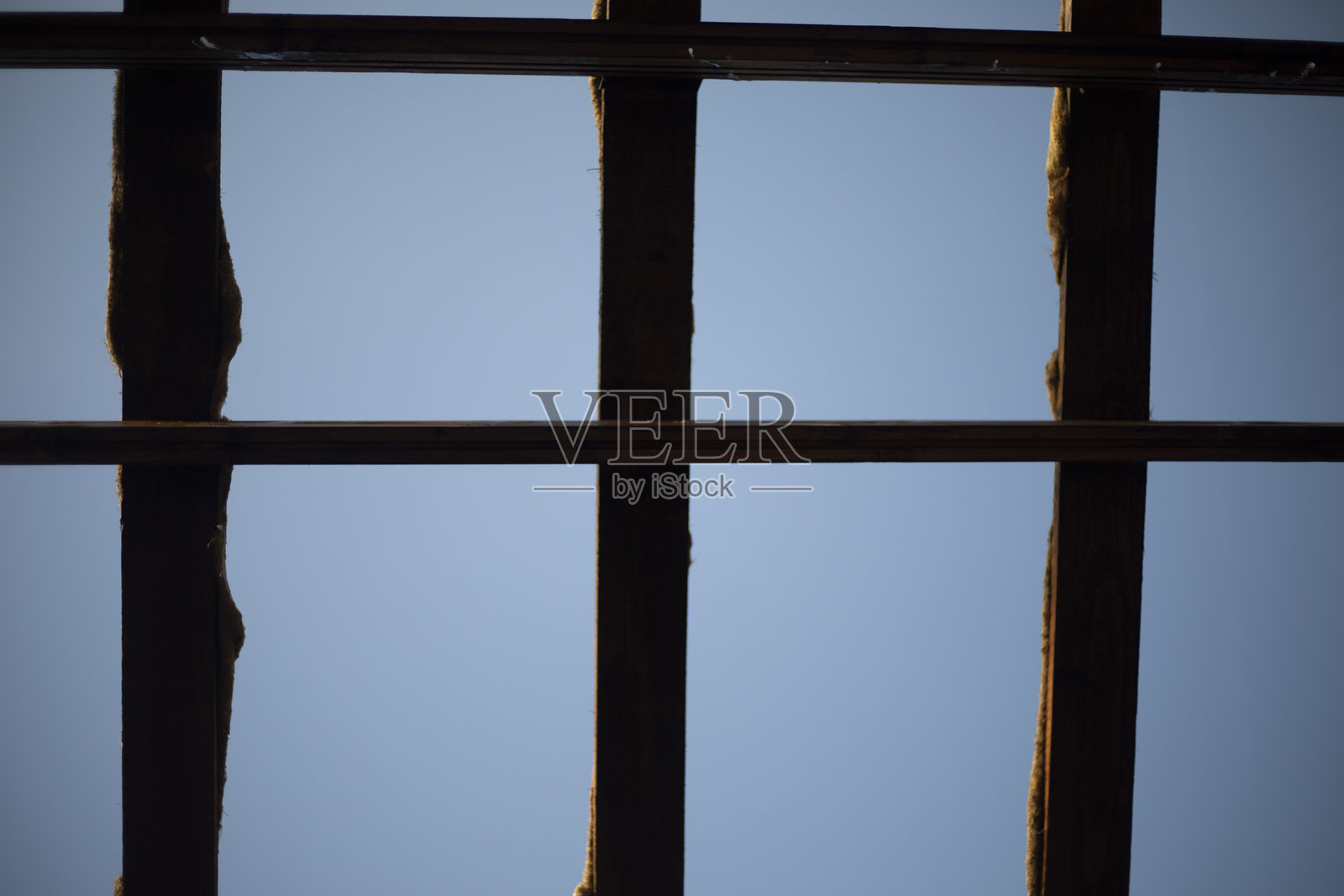 用木板制成的屋顶。顶部有格栅。天空透过木板。照片摄影图片