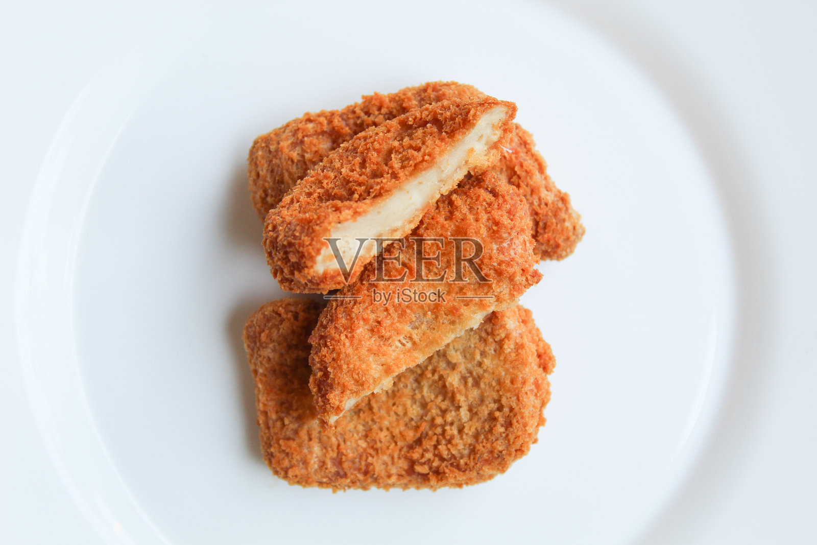 白色盘子上的切片炸鸡块，孤立在白色背景上，俯视图或平视图照片摄影图片