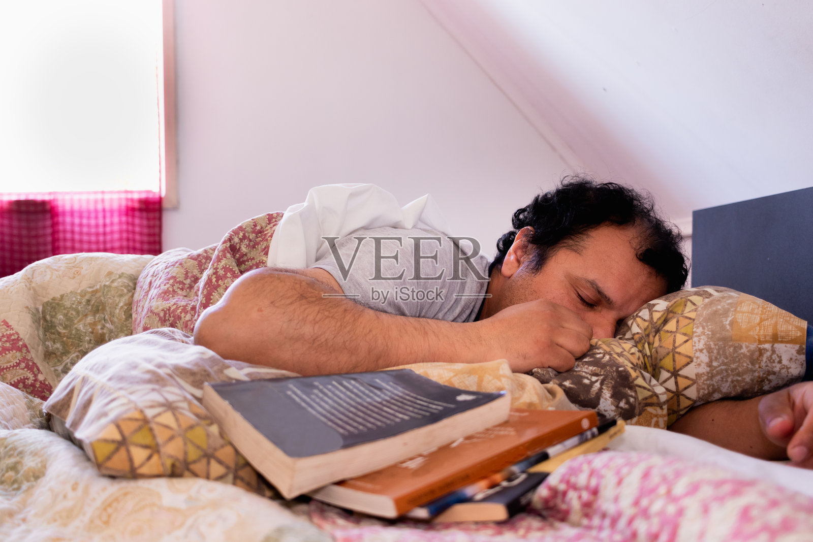 男人在床上睡觉，刚刚读完书。照片摄影图片