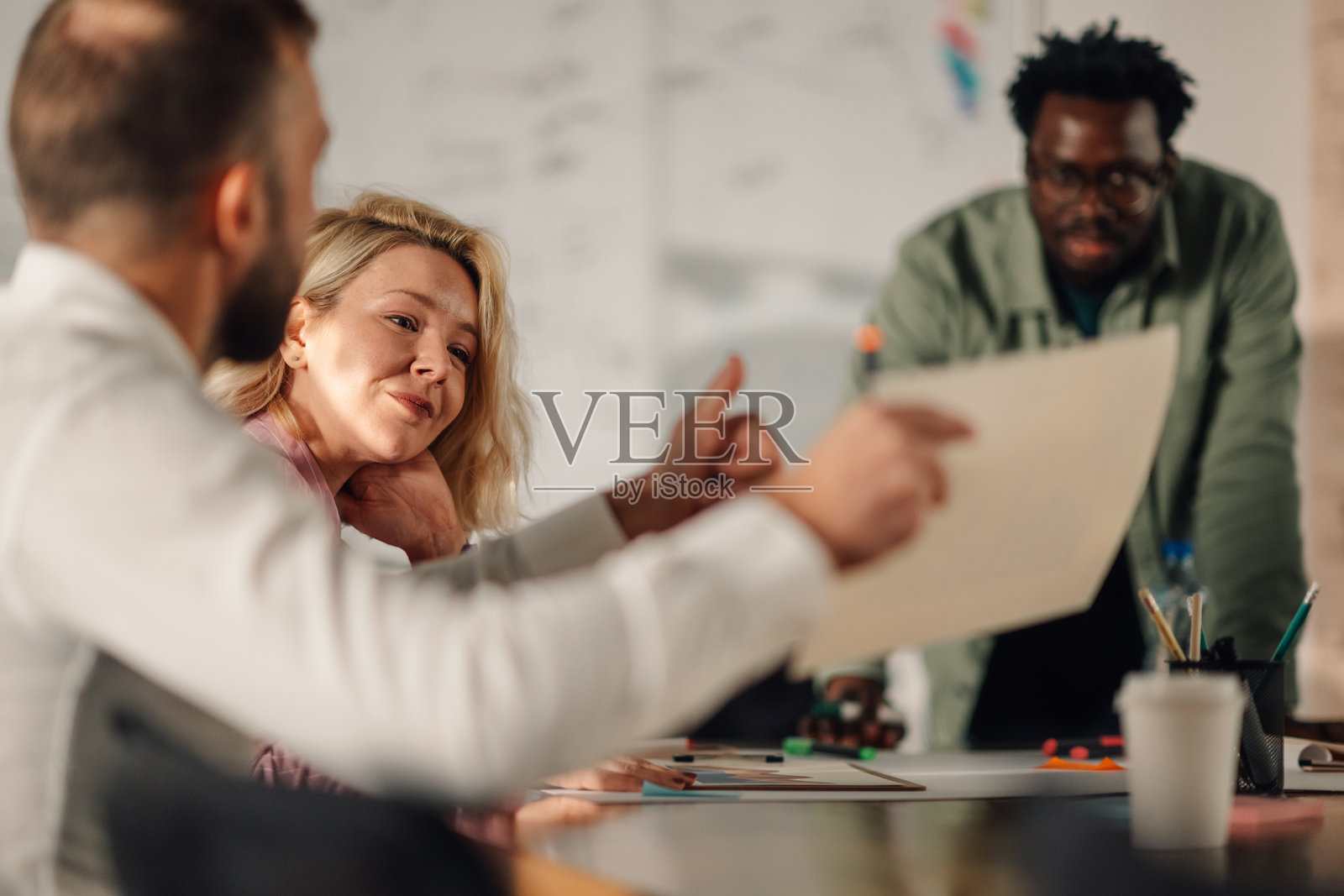 商务人士在办公室会议中分析文件照片摄影图片