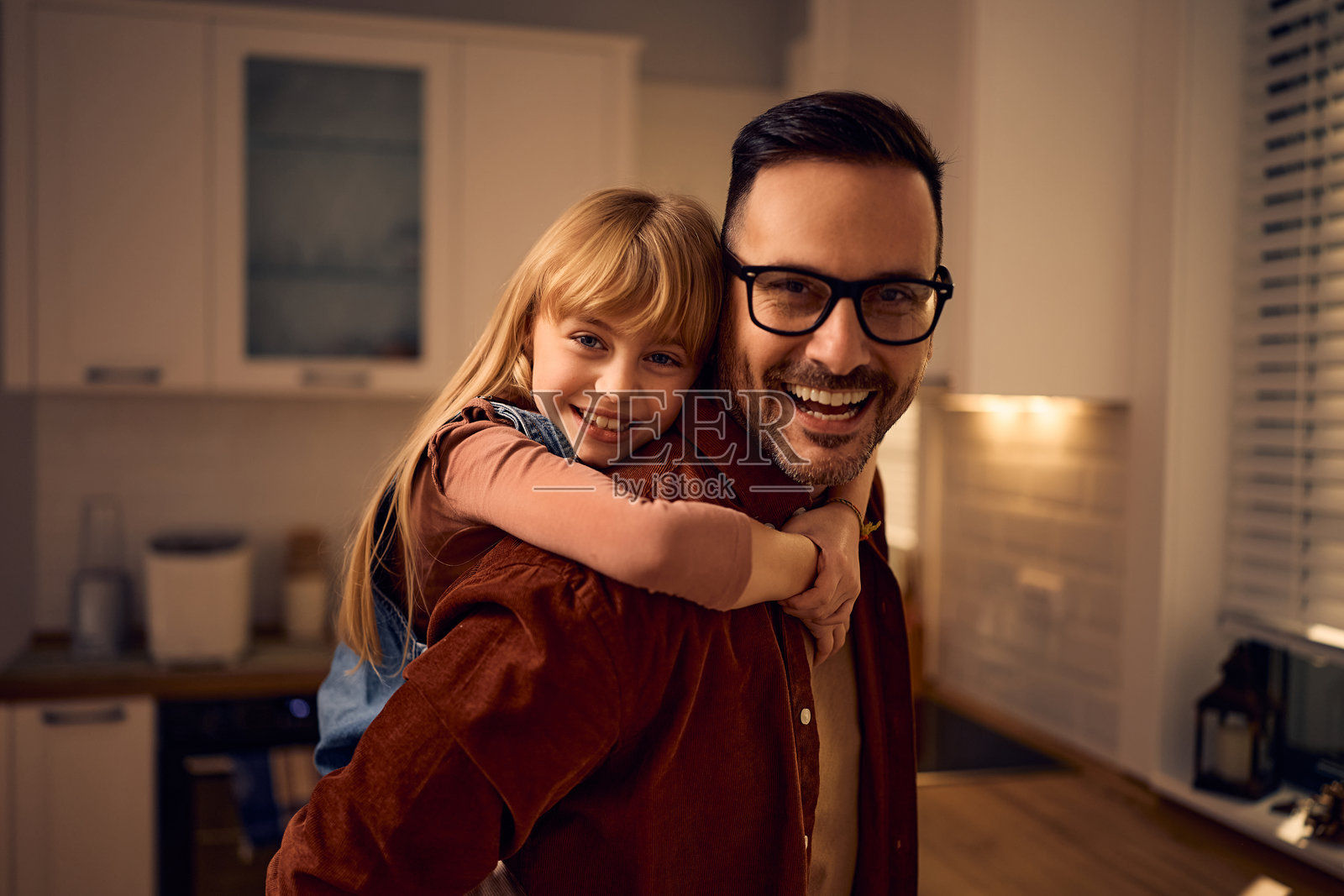 快乐的父亲和女儿在家中微笑着看向镜头。照片摄影图片