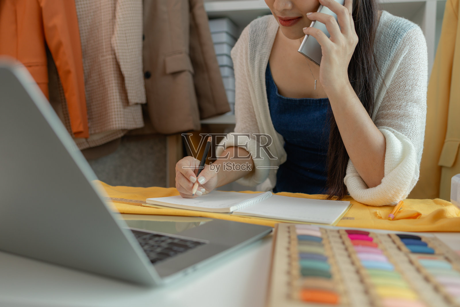 美丽的年轻女裁缝在工作，美丽的女性设计师在设计工作室，时尚设计师工作的特写，女裁缝在裁缝车间，服装设计师在工作室。照片摄影图片