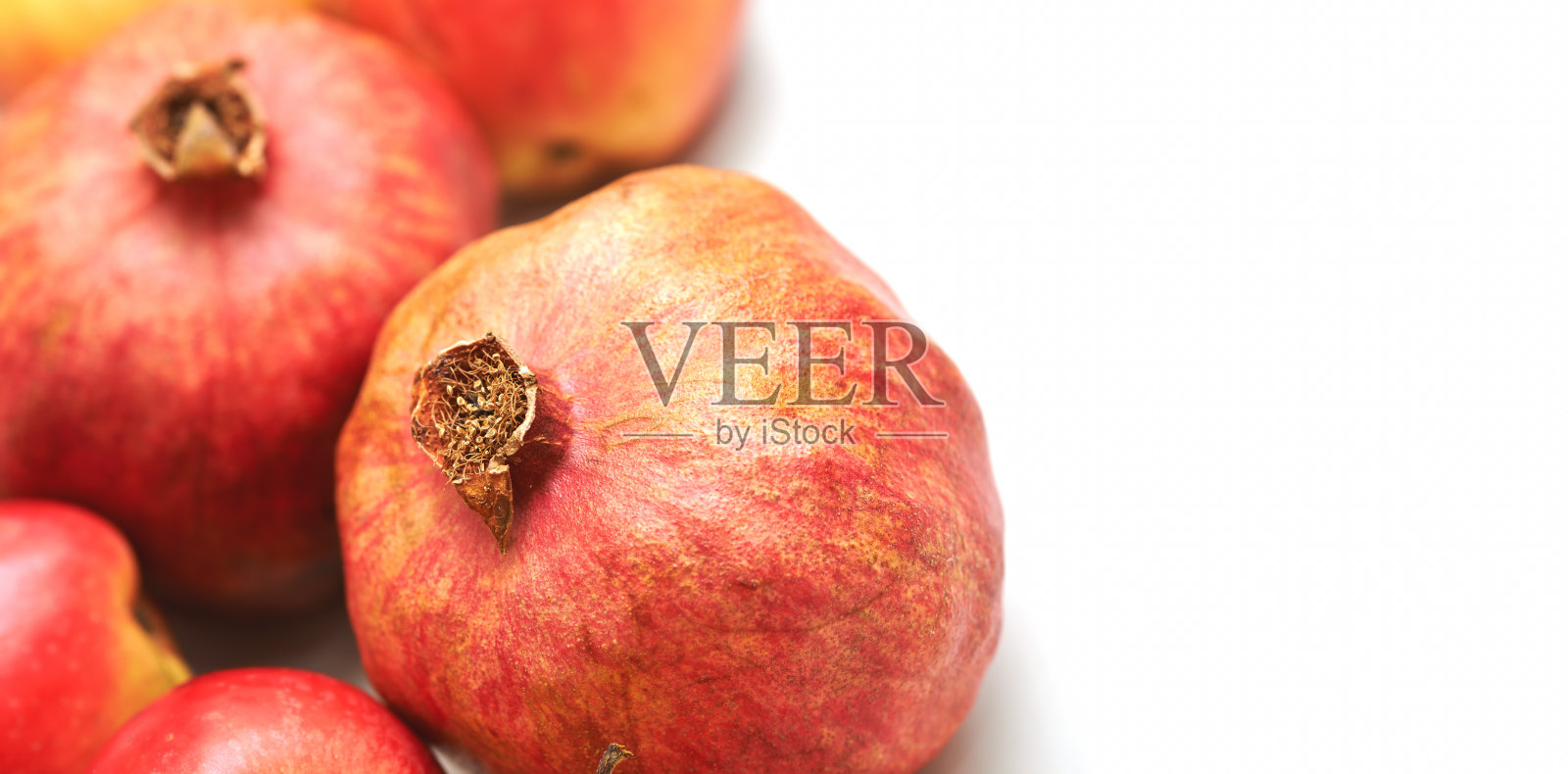 特写成熟的石榴，鲜艳的色彩映衬在白色背景上照片摄影图片