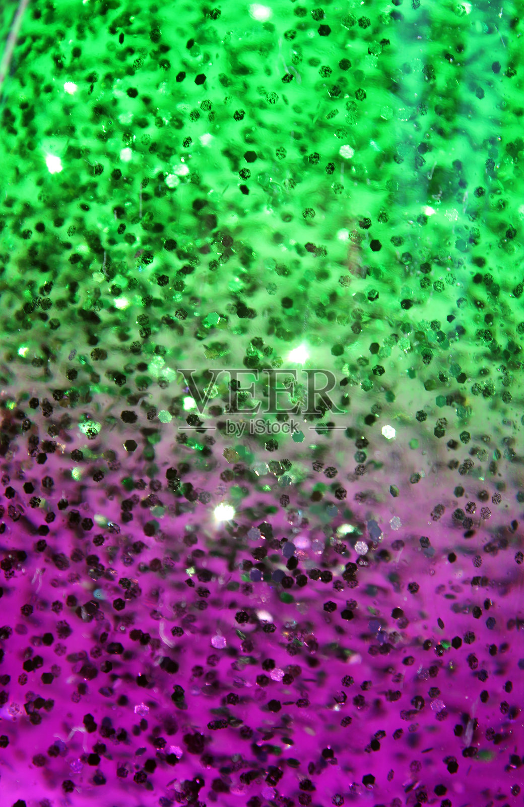 黑色闪光颗粒悬浮在绿色和紫色液体中的抽象纹理背景照片摄影图片
