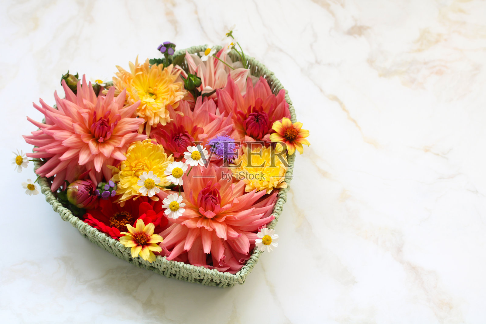 平铺，心形花篮里装满鲜花，右侧留有空位放面团。照片摄影图片