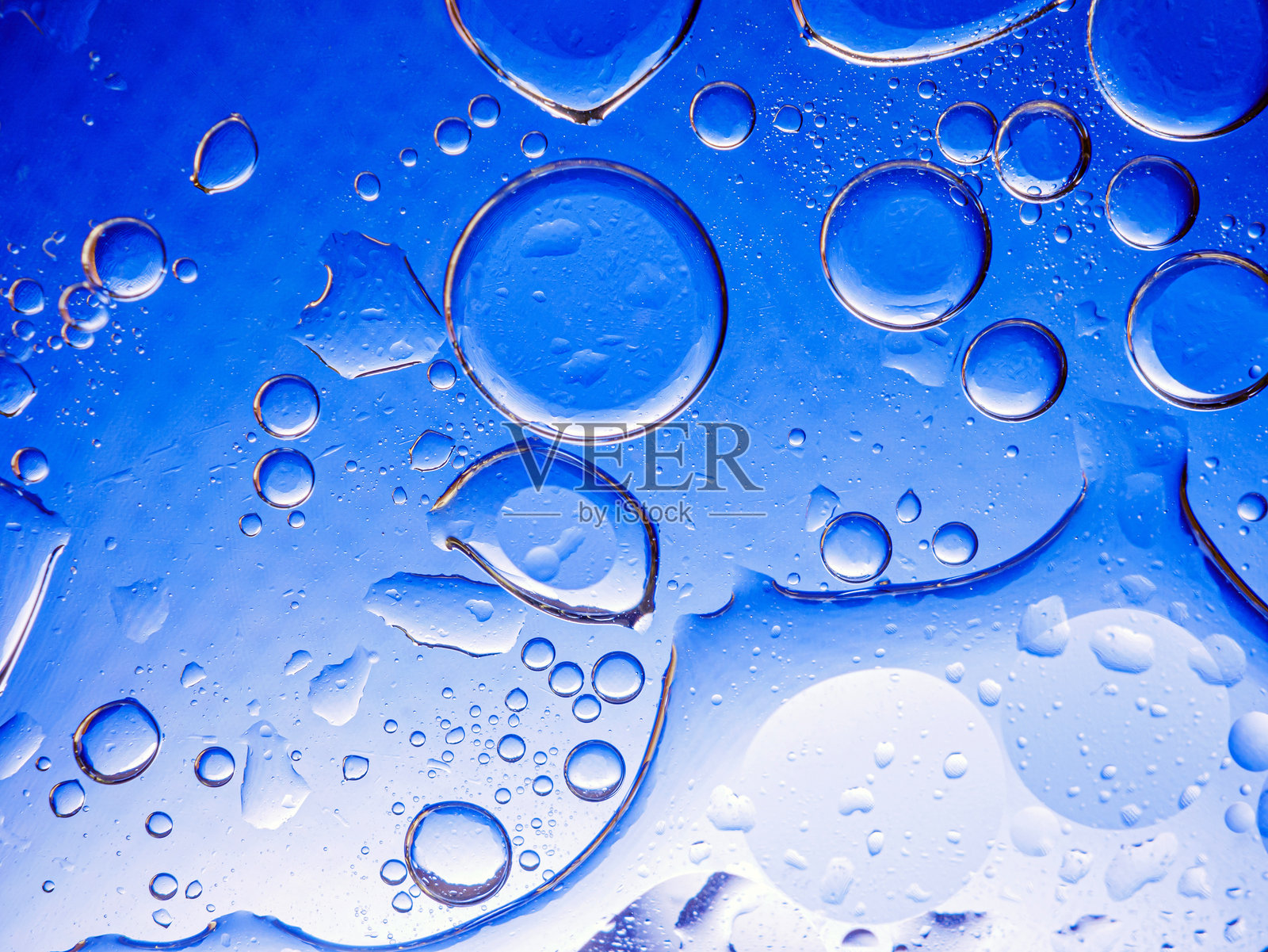 蓝色背景上的气泡。蓝色背景下海绵中的抽象氧气泡水。蓝色圆形水泡。照片摄影图片