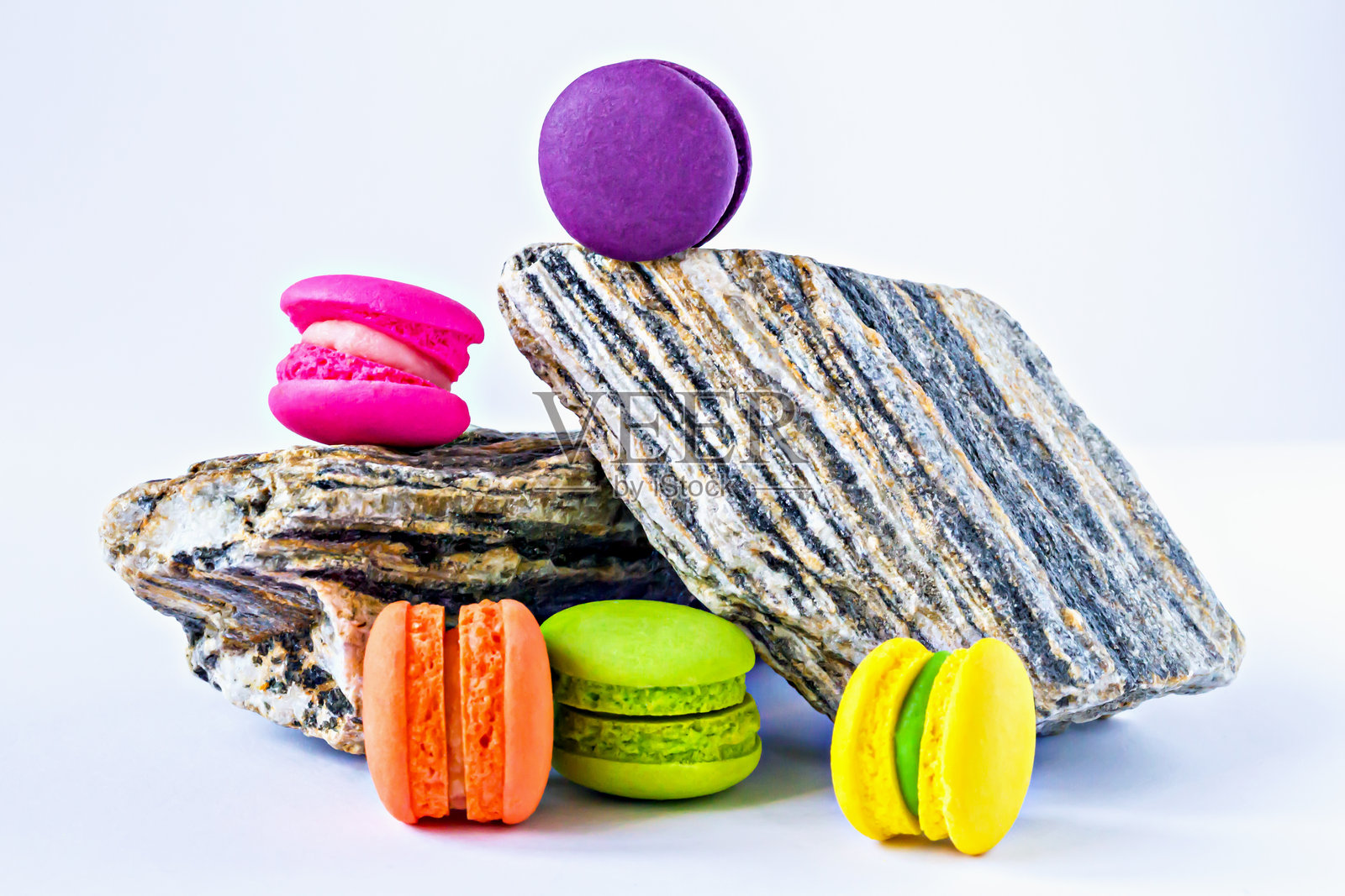 色彩缤纷的迷你马卡龙放在有纹理的岩石上照片摄影图片