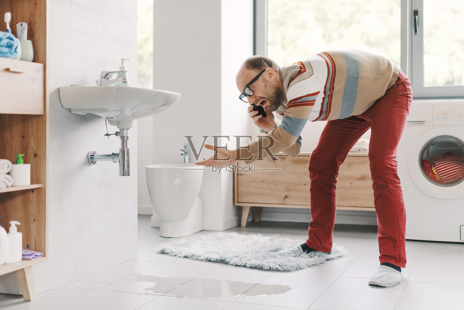 绝望的男人在打电话给水管工照片摄影图片