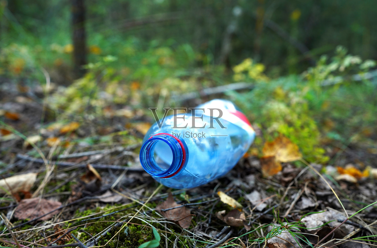 森林小路上被丢弃的塑料瓶。自然中的垃圾，可重复使用的产品。照片摄影图片