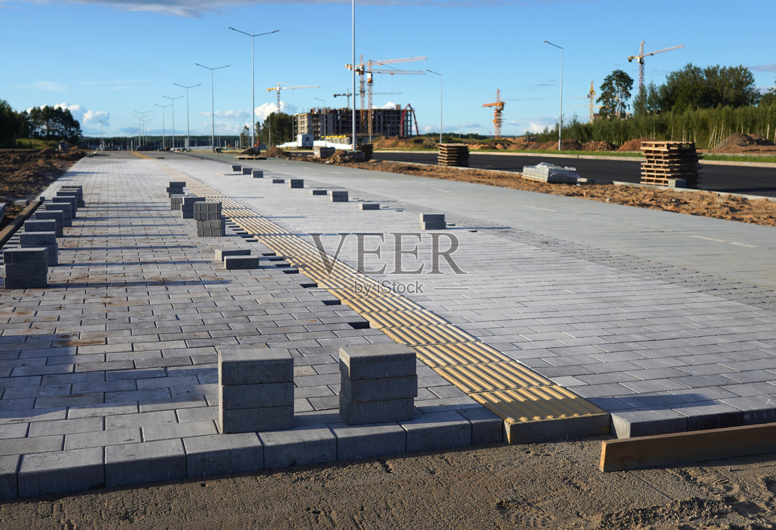 城市街道上的人行道砖。施工现场铺设铺路石。照片摄影图片