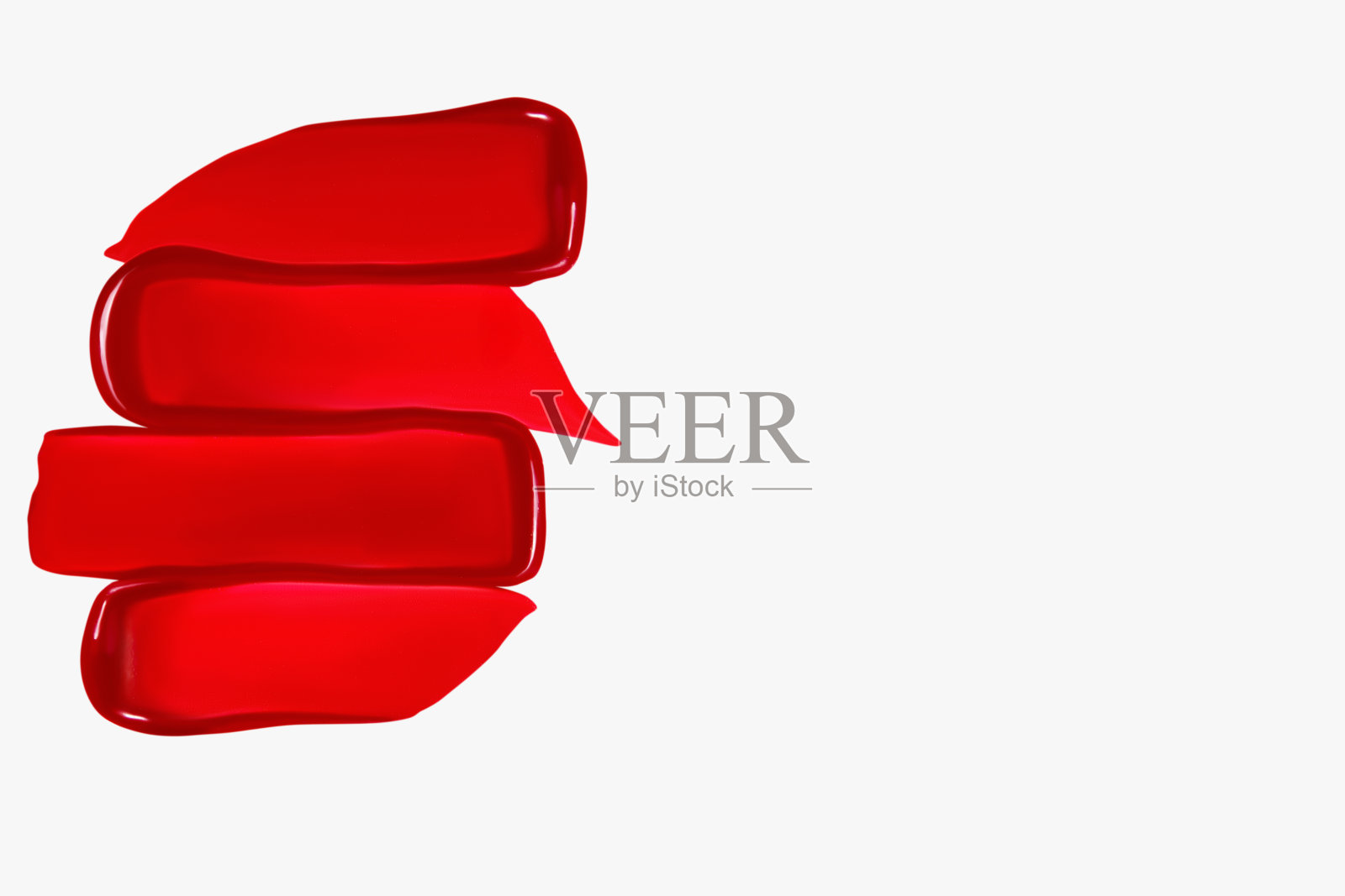 红色口红涂抹的组成在浅色背景上。美容产品，化妆品质地。照片摄影图片