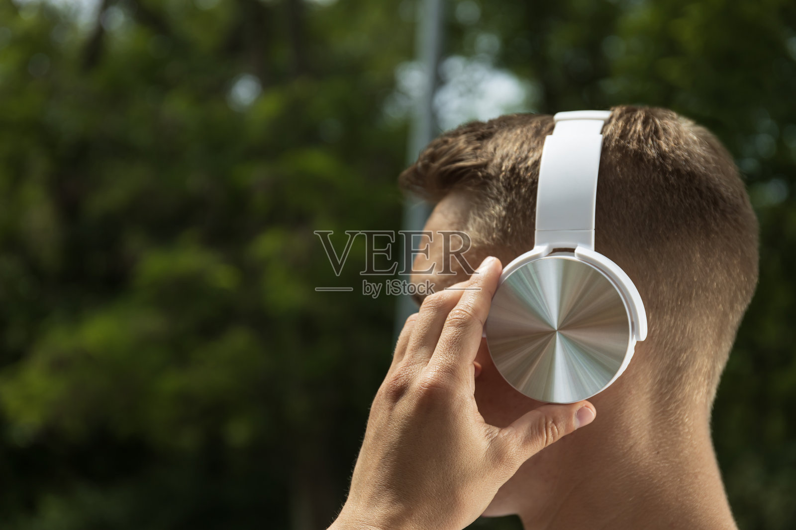 户外侧面视角的戴银色耳机的男子照片摄影图片