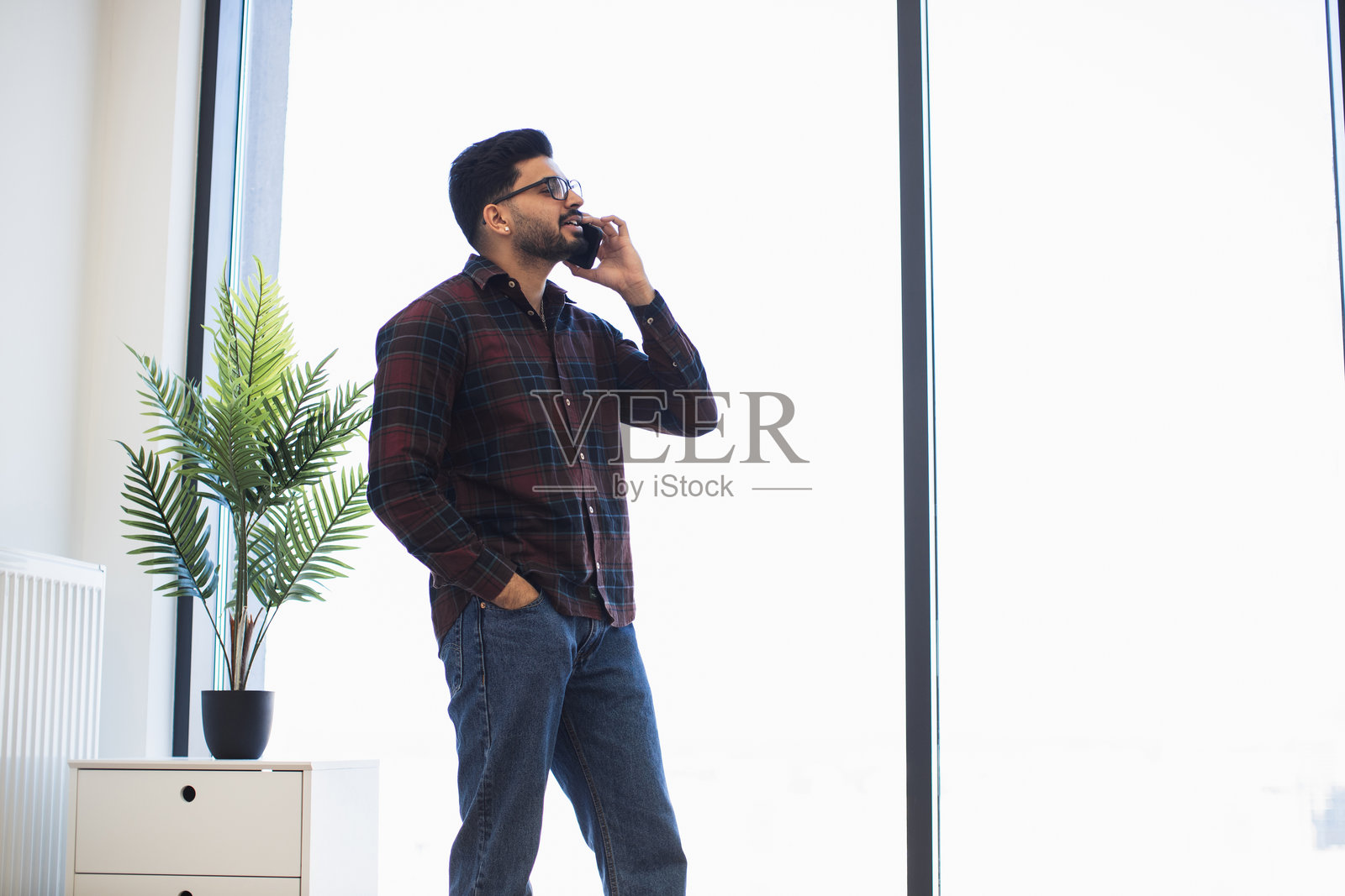 年轻男子在现代办公室环境中打电话照片摄影图片