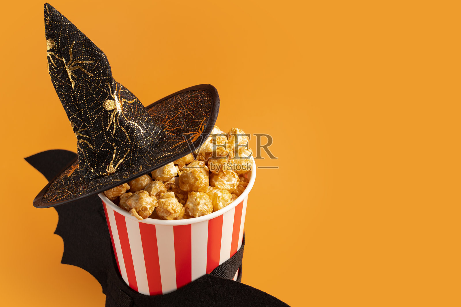 万圣节电影，带翅膀的爆米花和万圣节帽子，甜点派对布置，装满谷物的桶，以及为这个恐怖庆祝活动增添乐趣的娱乐元素。照片摄影图片