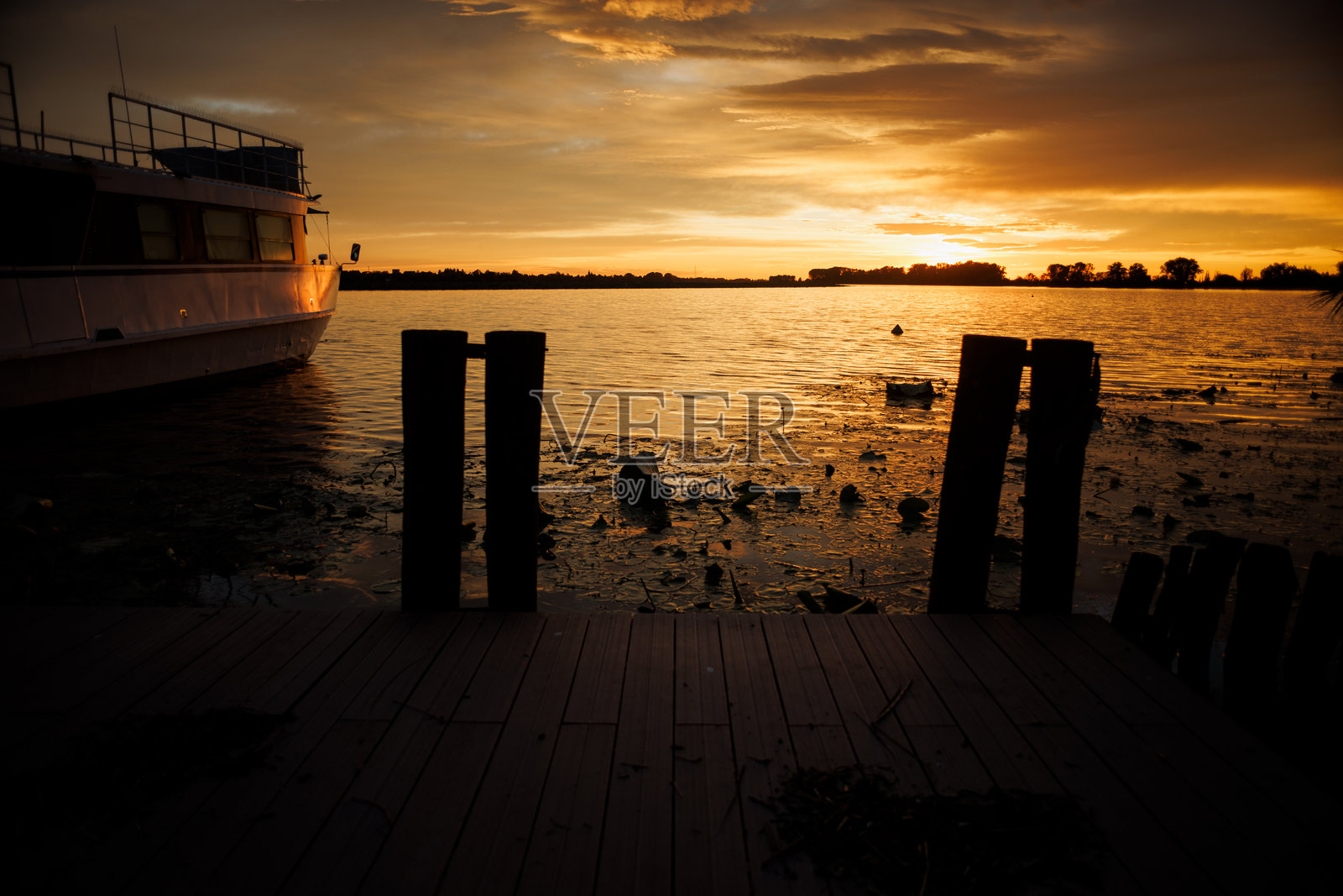 曼图瓦的敏奇奥河上的码头，设有传统的木桩和停靠在旁的船只照片摄影图片