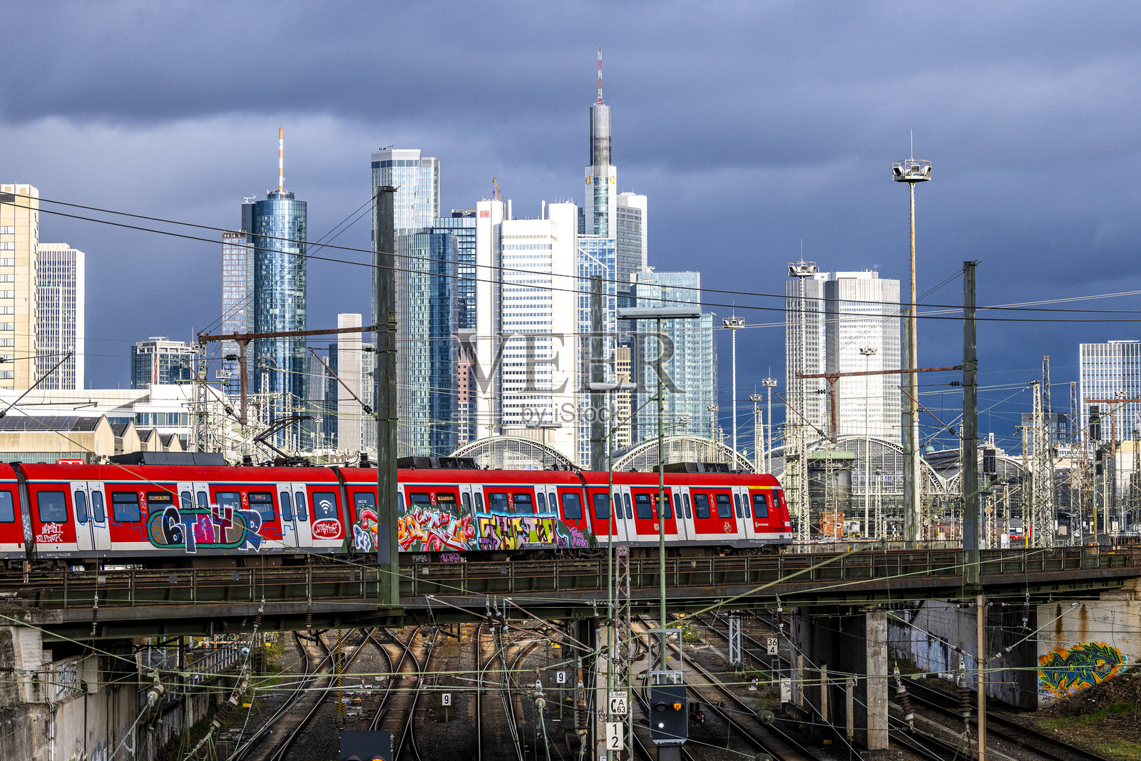 火车在铁路轨道和法兰克福金融区天际线的背景下行驶照片摄影图片