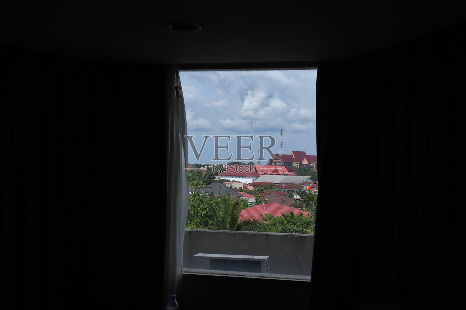 透过分开的窗帘看到的城市天际线照片摄影图片