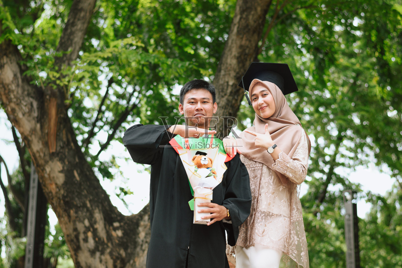 兄弟姐妹庆祝他们的小弟弟毕业的肖像照片摄影图片