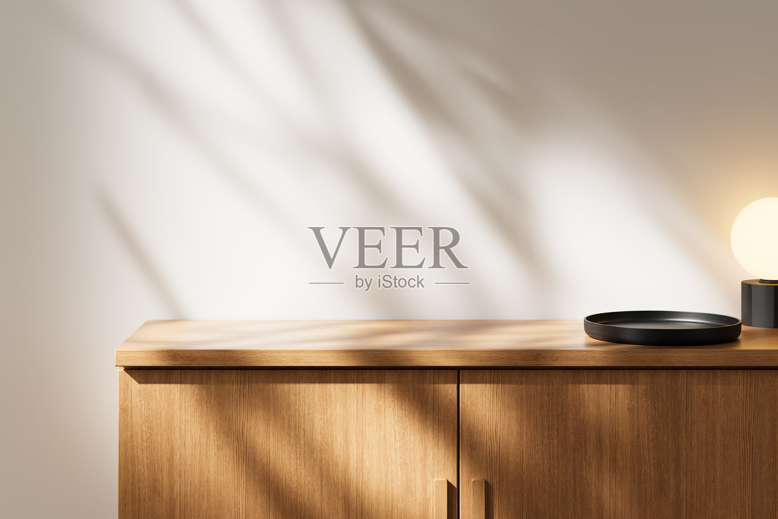 木质台面上放着黑色托盘和现代灯具，阴影投射在白色墙壁上。极简设计概念。3D渲染。照片摄影图片