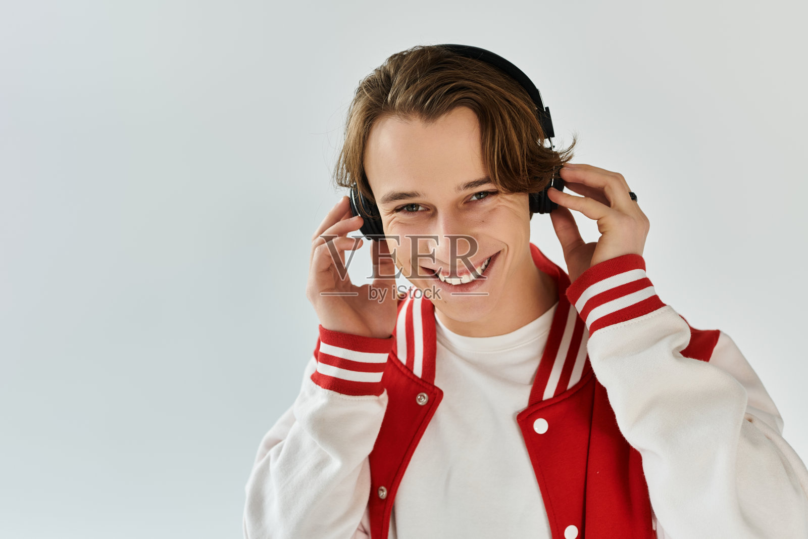 自信的年轻男子穿着时尚的飞行员夹克，在充满活力的工作室环境中摆姿势照片摄影图片