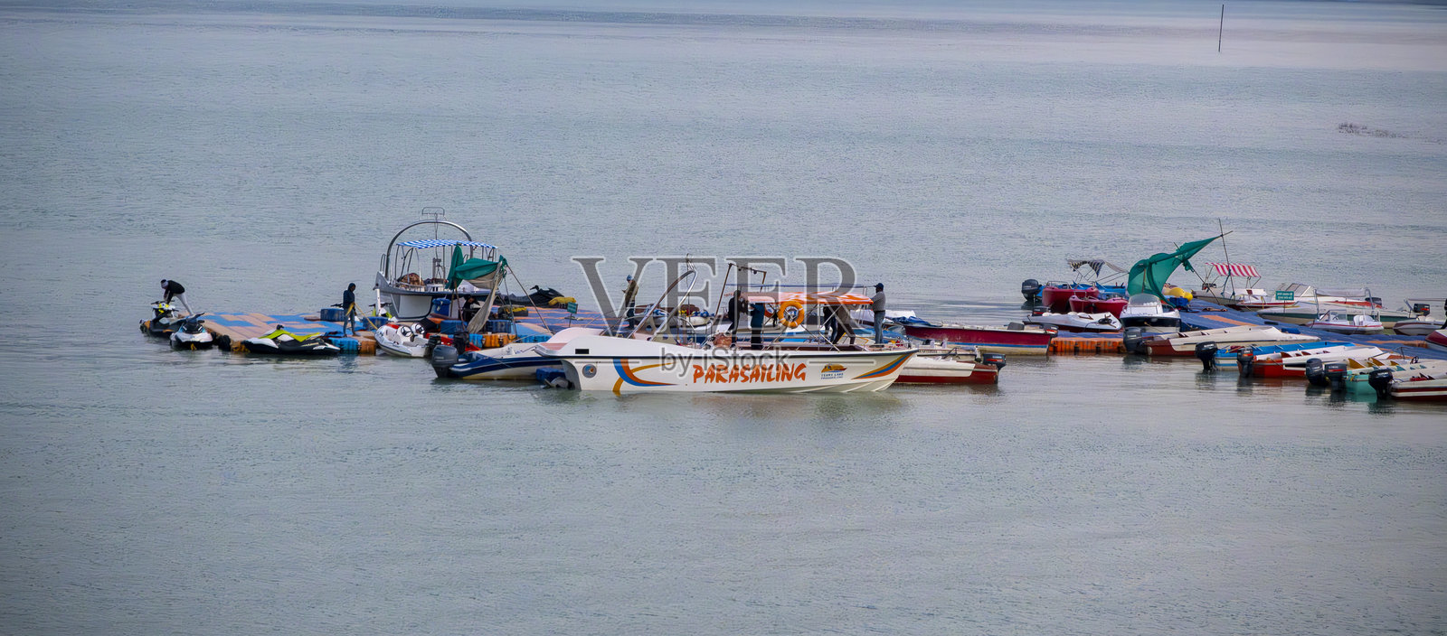 湖面上为游客提供了滑翔伞船和其他各种船只，突显了特赫里湖为游客提供的冒险选择。照片摄影图片