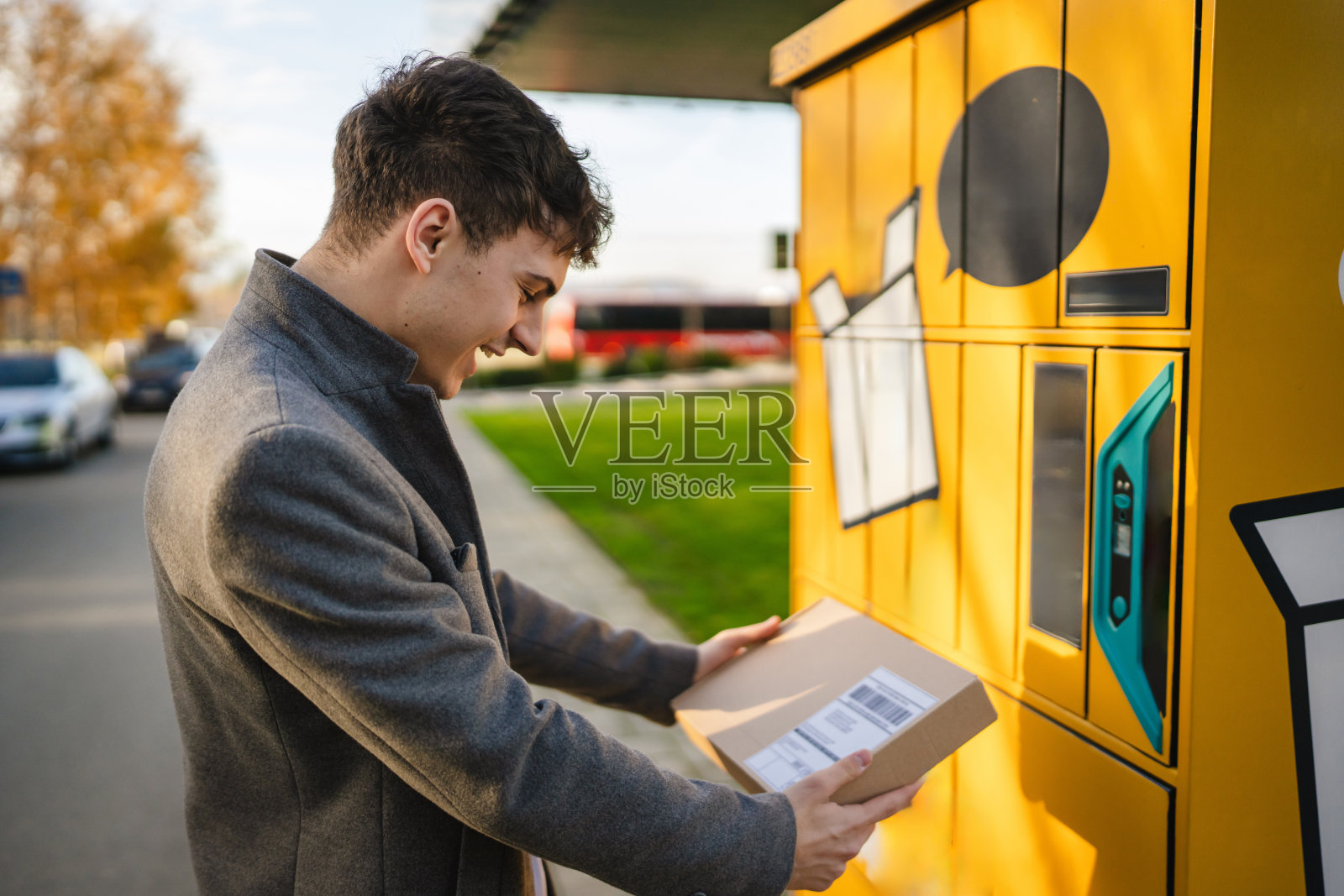 年轻男子在街上的包裹机上取包裹照片摄影图片