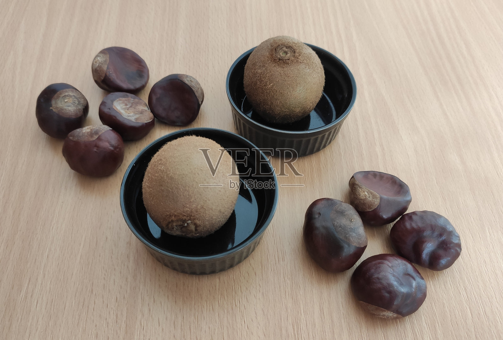 桌子上的猕猴桃和闪亮的棕色栗子照片摄影图片