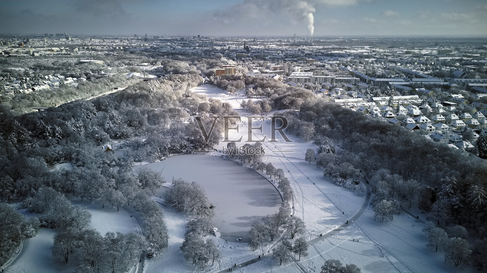冬季的慕尼黑公园和城市上方覆盖着厚厚的雪。照片摄影图片