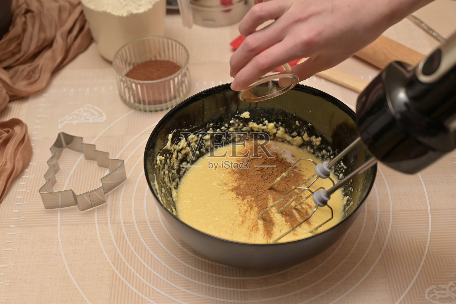 圣诞节自制烘焙，姜饼的烘焙原料，女性正在黑色碗中向面团添加香料照片摄影图片