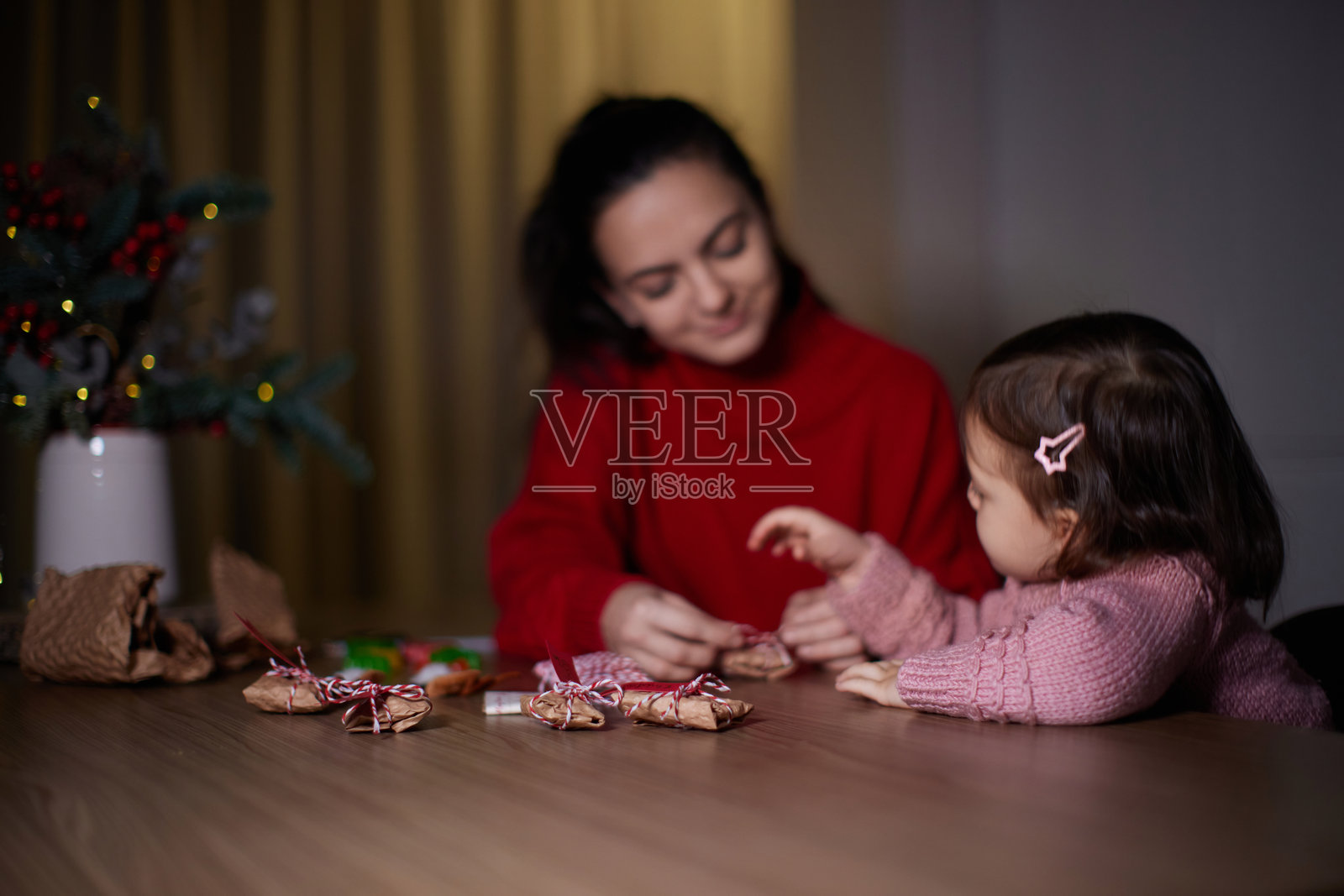 母亲和她的小女儿在家里包裹圣诞礼物照片摄影图片