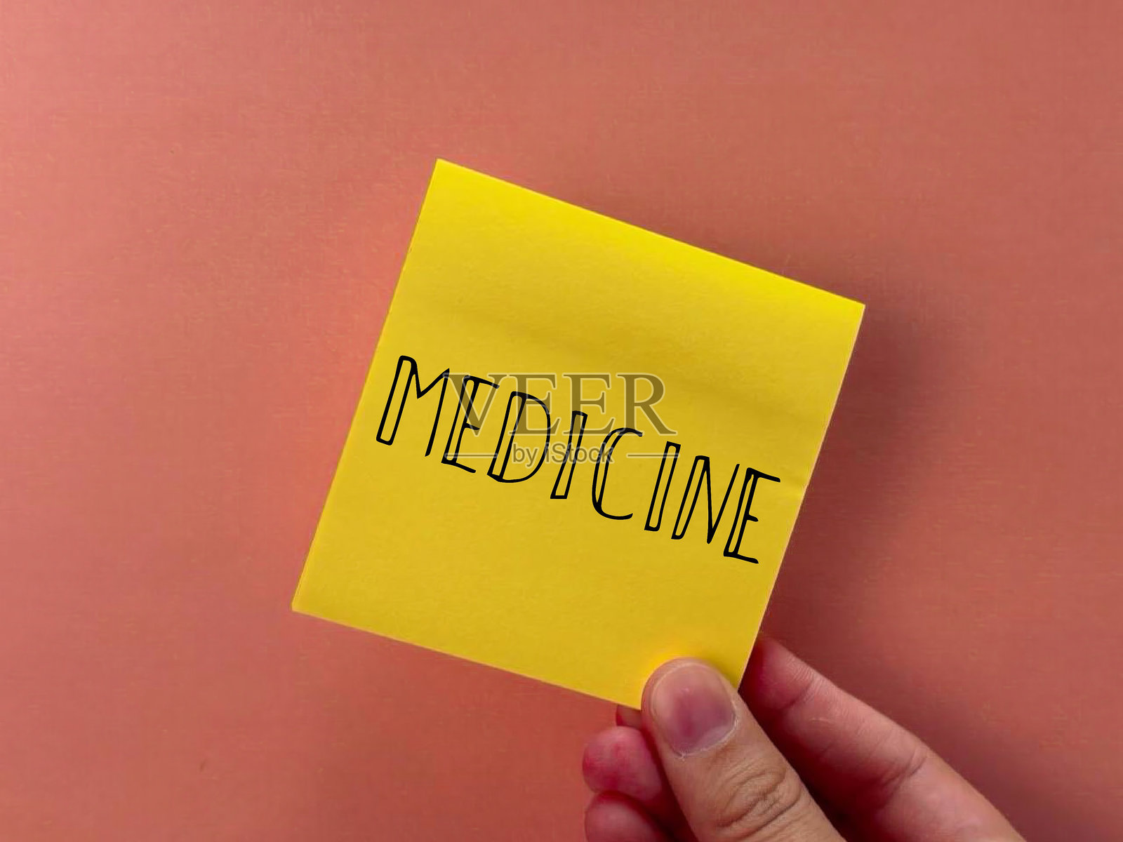 药品的字样。手握着纸张，上面写着药品。用于广告医疗服务的横幅。纸质背景上的药品字样。照片摄影图片