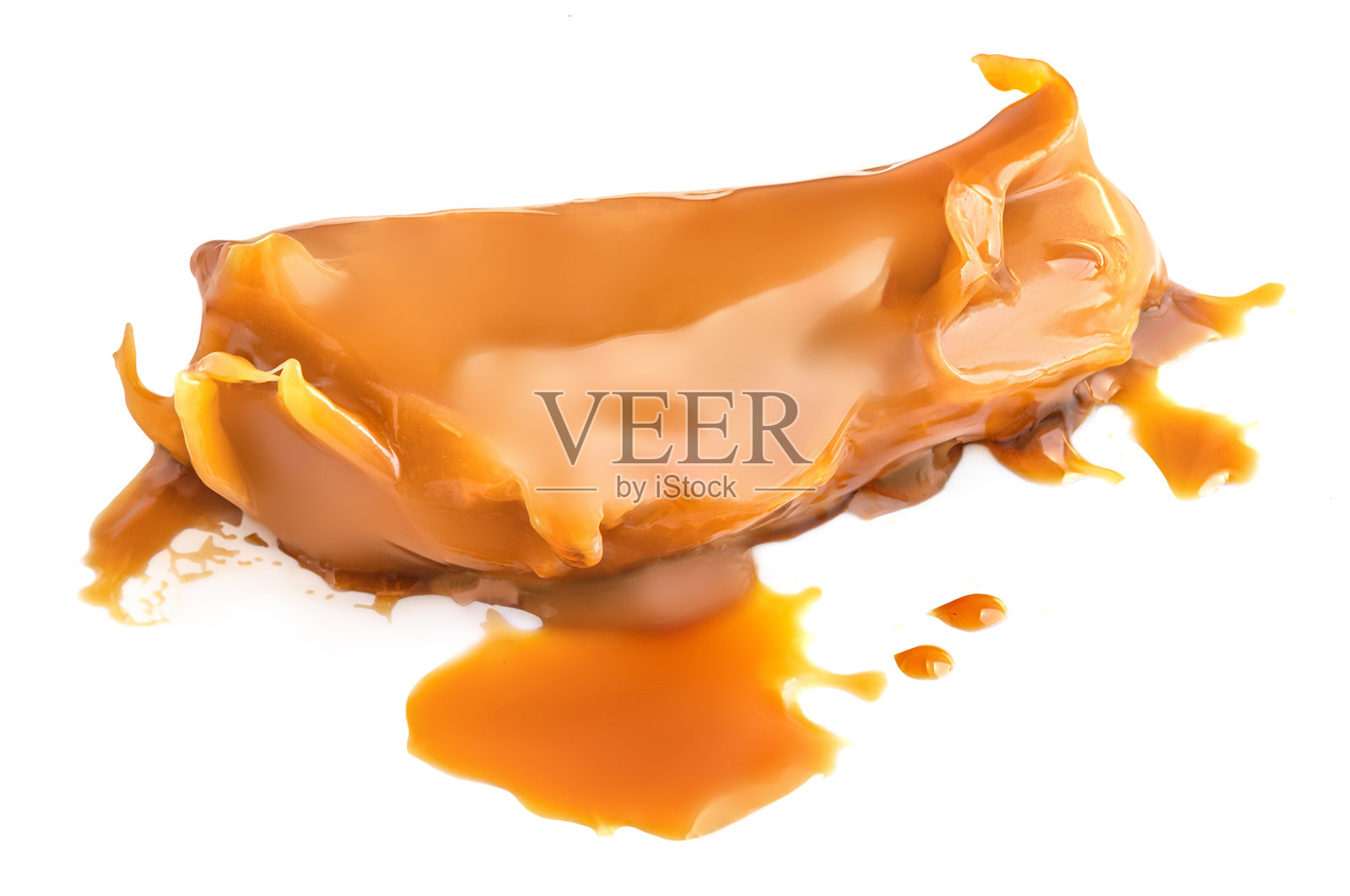 焦糖孤立在白色背景上。流动的焦糖酱特写。融化的焦糖块。照片摄影图片