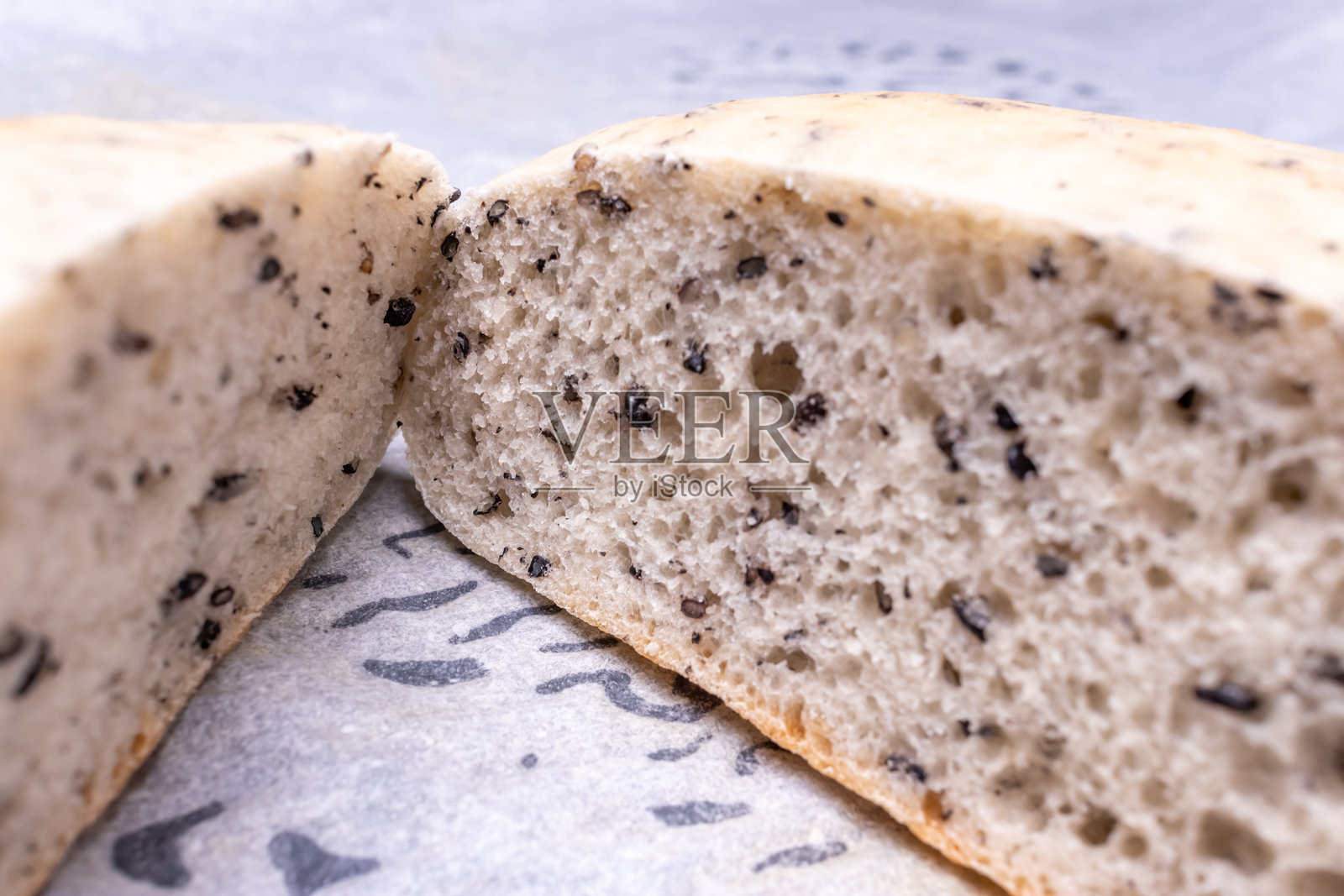 新鲜出炉的白面包，上面撒有黑芝麻照片摄影图片