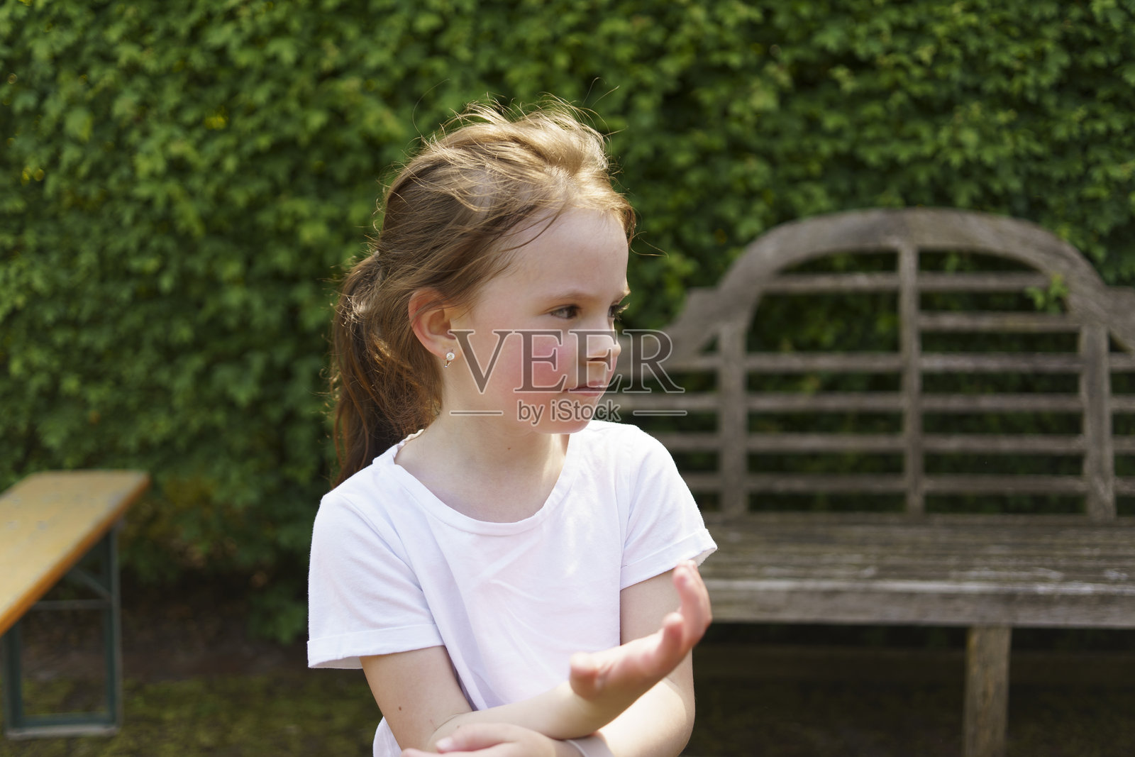 美丽快乐的女孩穿着白色T恤，在夏季户外玩得很开心。体现了一个活泼、好动、真诚的孩子的概念。照片摄影图片